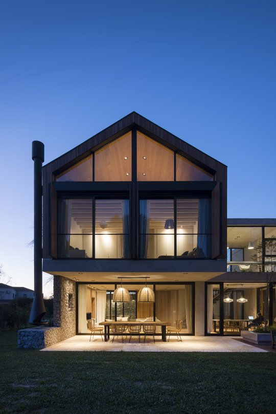 fachada de casa moderna con techo a dos aguas y ventanales grandes — proyecto Casa Carol, por Estudio Lak, en Club Newman