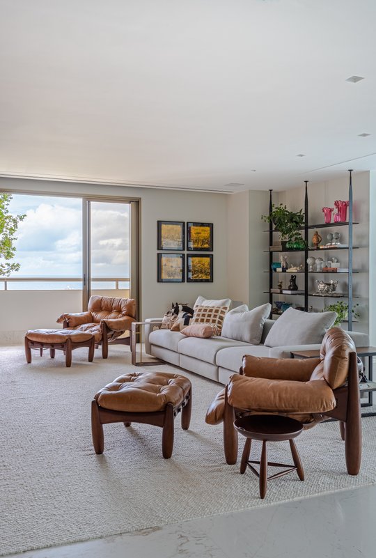 Living moderno con sillones cuero, sofá gris y vista al mar — proyecto Apto S | A, por Arquitetura Paulo Melo E Paulo