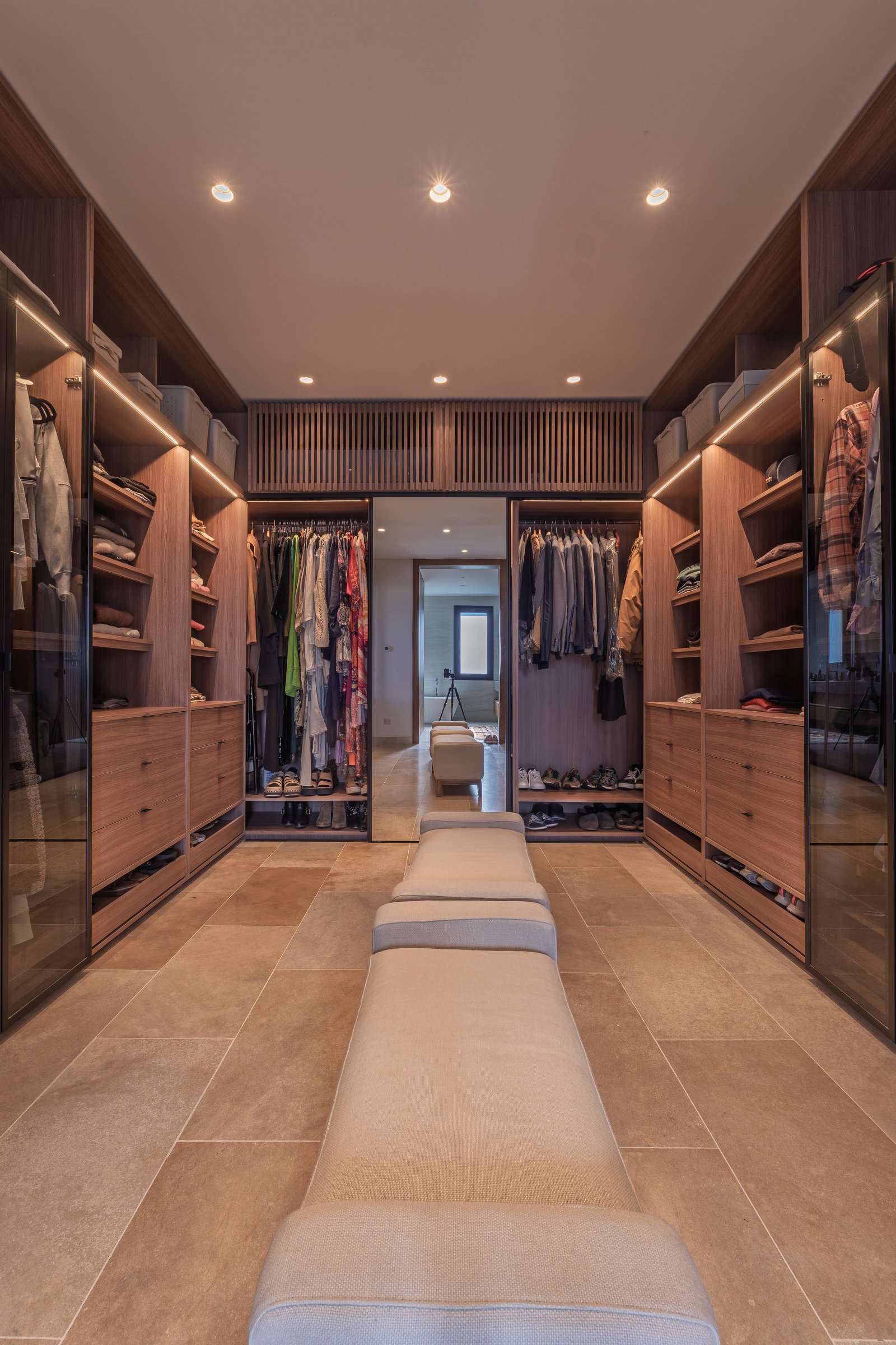 Impecable vestidor moderno con muebles de madera y piso de piedra — proyecto PilarA - Estudio Pacifica, por ABEJA CONCEPT, en Pilar