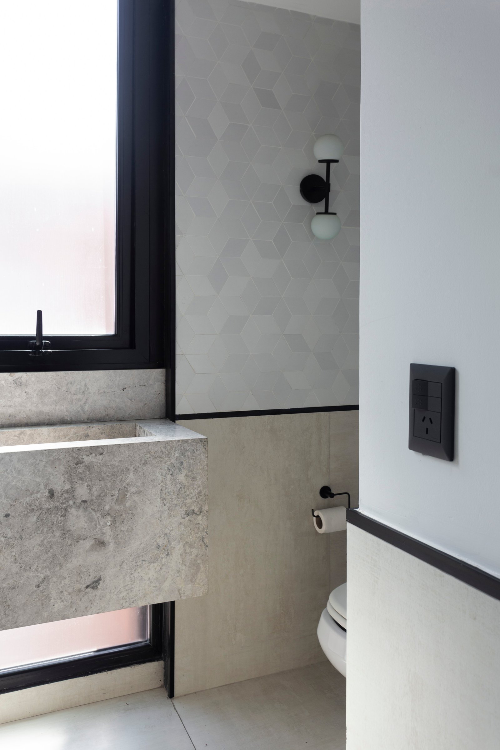 Baño moderno con lavabo de hormigón y papel tapiz geométrico — proyecto La Pampa, por JT ARQUITECTURA, en Buenos Aires