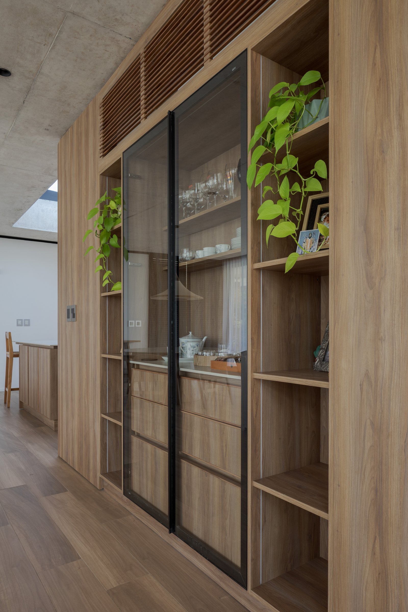 Cocina moderna con estanterías de madera, hormigón y detalles de vidrio — proyecto Casa PLANALTO, por Grupo CRBN, en Av. Pres. Perón 10298