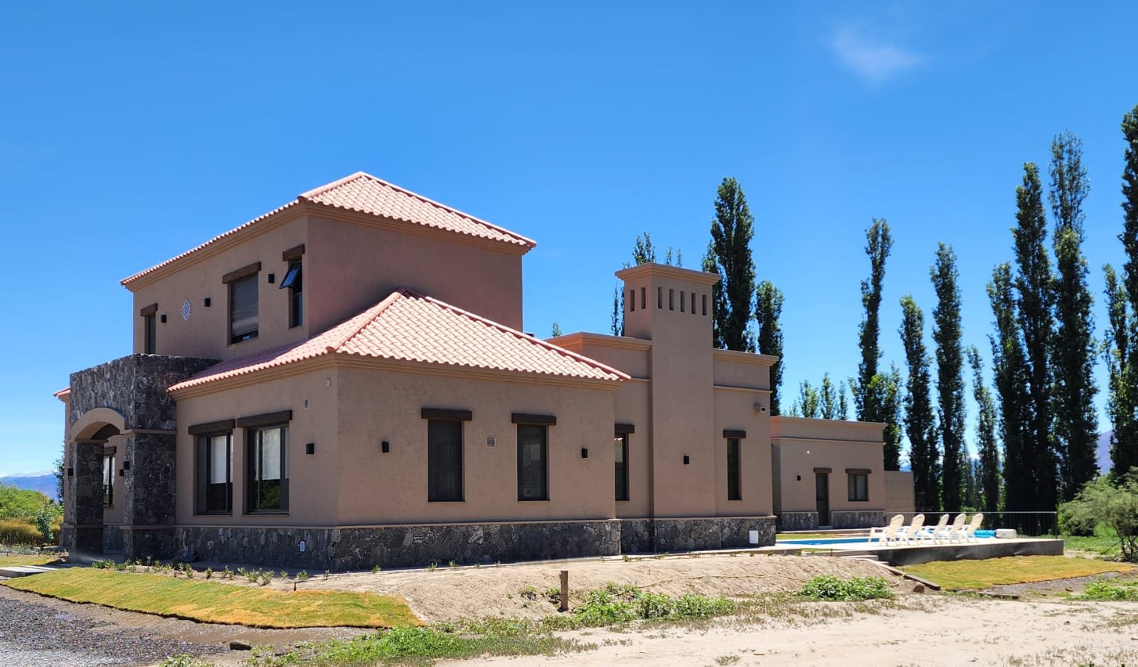 Casa moderna estilo mediterráneo con piscina y rodeada de árboles — proyecto Ca La Estancia, por Luciana González Anderson, en Cafayate