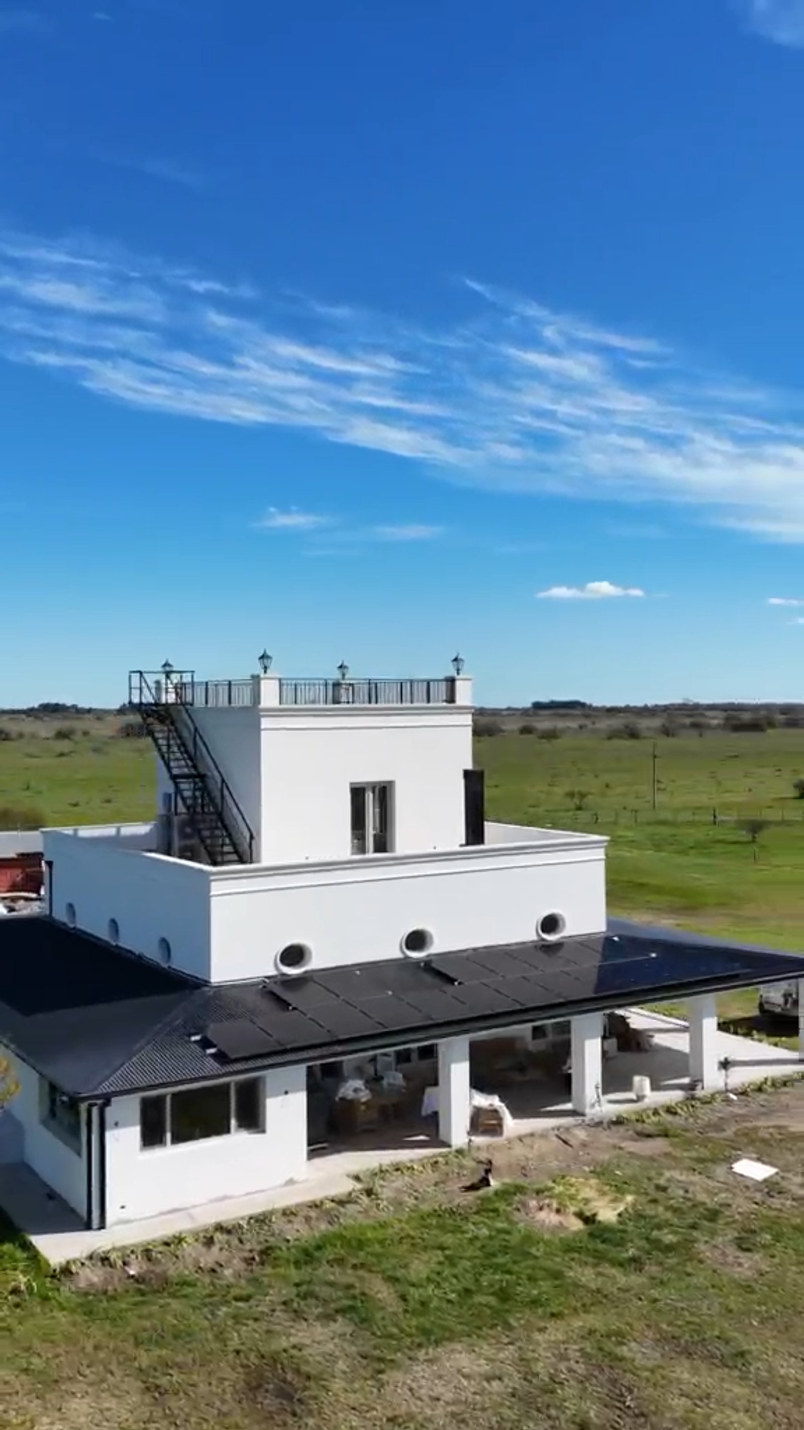 Fachada moderna rural con torre y escalera exterior — proyecto Estrella del Este, por efergía, en La Plata