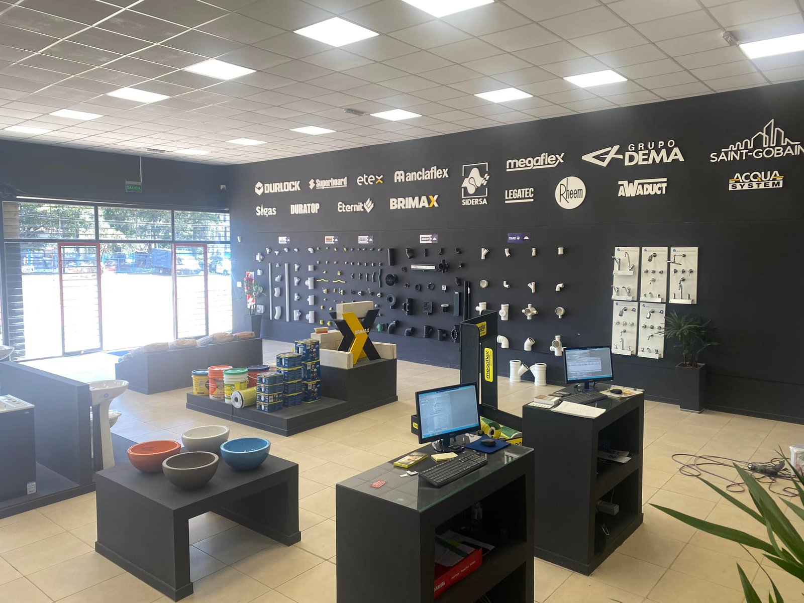 Showroom de venta de materiales con paredes negras y exhibidores modulares — proyecto Edify Posadas, por Arquitecto Gustavo Maidana, en Posadas