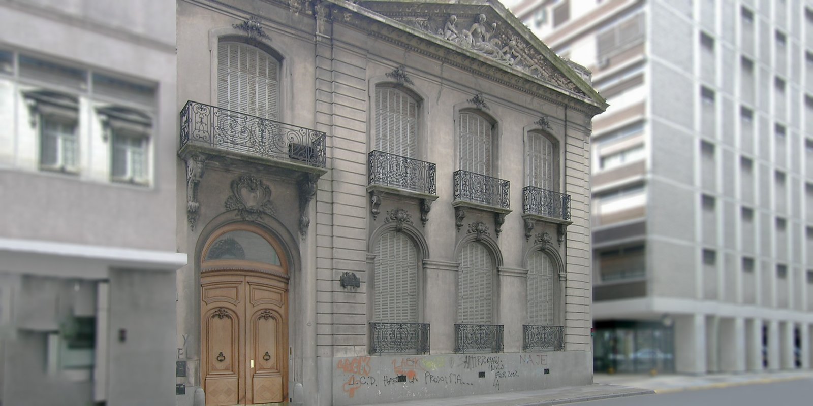 Fachada clásica con puerta doble de madera y balcón ornamentado — proyecto Palacio Mihura, por M. Victoria Menendez | Arq. Esp. en Patrimonio, en Av. Gral. Las Heras 1725