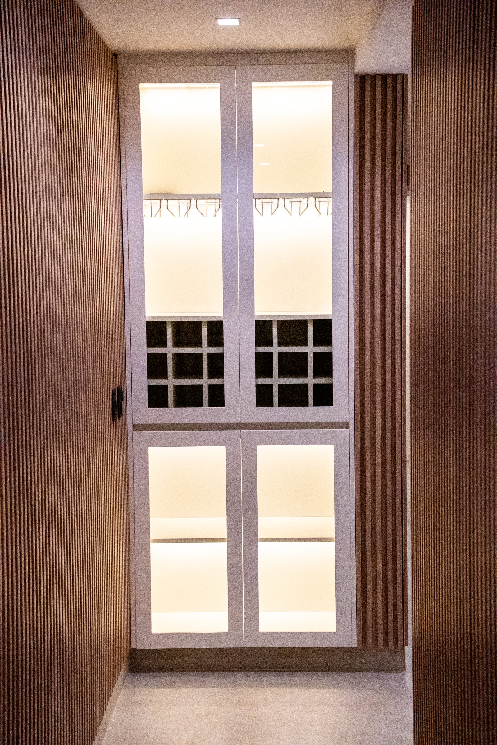 Armario empotrado moderno con puertas blancas y listones de madera — proyecto QUINTANA, por ESTUDIO TEZ, en Recoleta