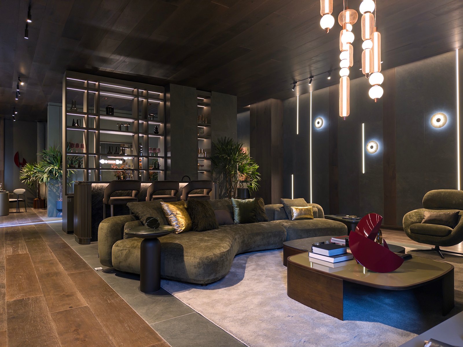 Sala de estar moderna com sofá curvo, mesa vermelha escultural e iluminação dourada — projeto Casa Foa Madero Harbour, por Vite Porcellanato, em Buenos Aires