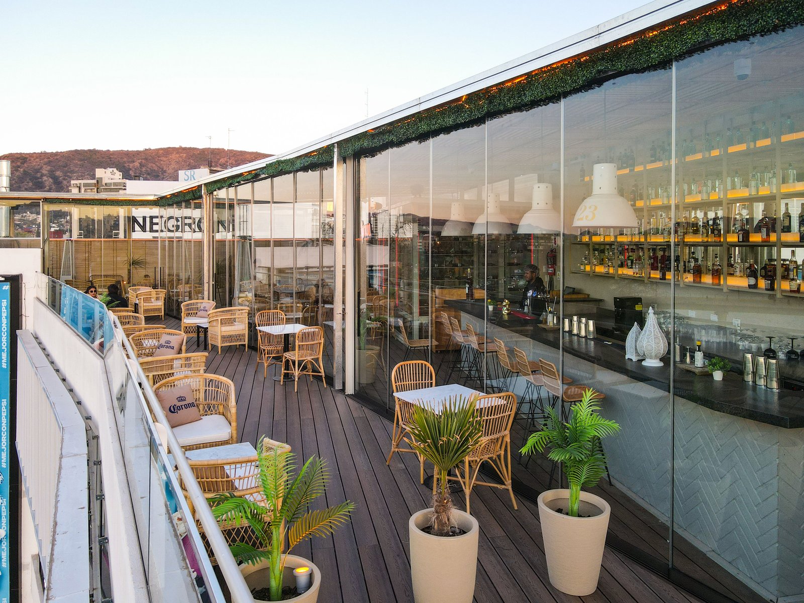 Terraza de restaurante con vistas panorámicas y mobiliario de ratán — proyecto NEGRONI SHOPPING WO CARLOS PAZ, por GARCIA RECTA DESIGN, en 25 de diciembre 70 8
