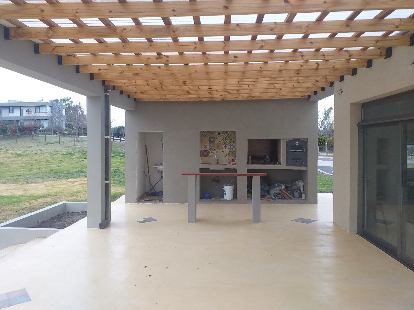 Quincho moderno con pérgola y piso de cemento — proyecto Vivienda unifamiliar en Chacras de la reserva , por Sep Arquitectura , en B2814 Los Cardales