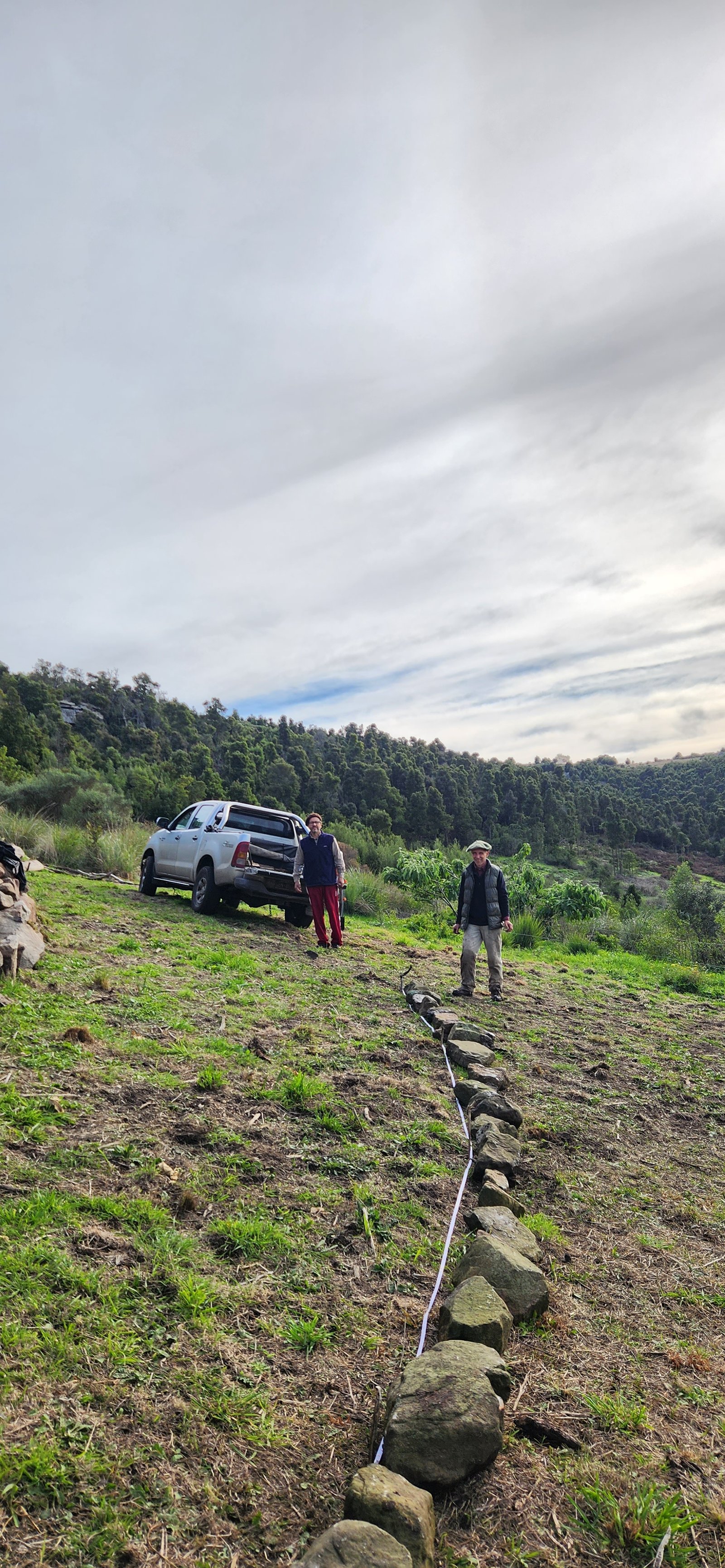 construcción de muro de piedra en montaña con camioneta — proyecto Reserva Naural Paititi, por Estudio Rifahi, en Sierra de los Padres