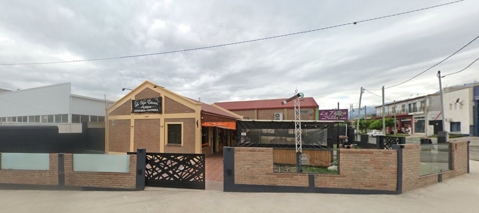 Fachada comercial con portón metálico decorativo — proyecto confiteria vieja estacion, por Diego ceballos, en Merlo