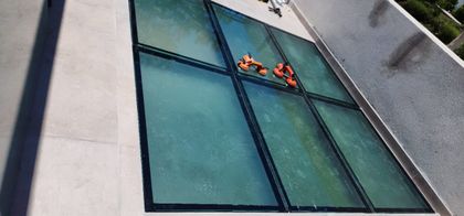 Fachada moderna con limpiadores de ventanas robóticos — proyecto Piso Opacid 30mm transitable, por Cristalcenter, en Canning