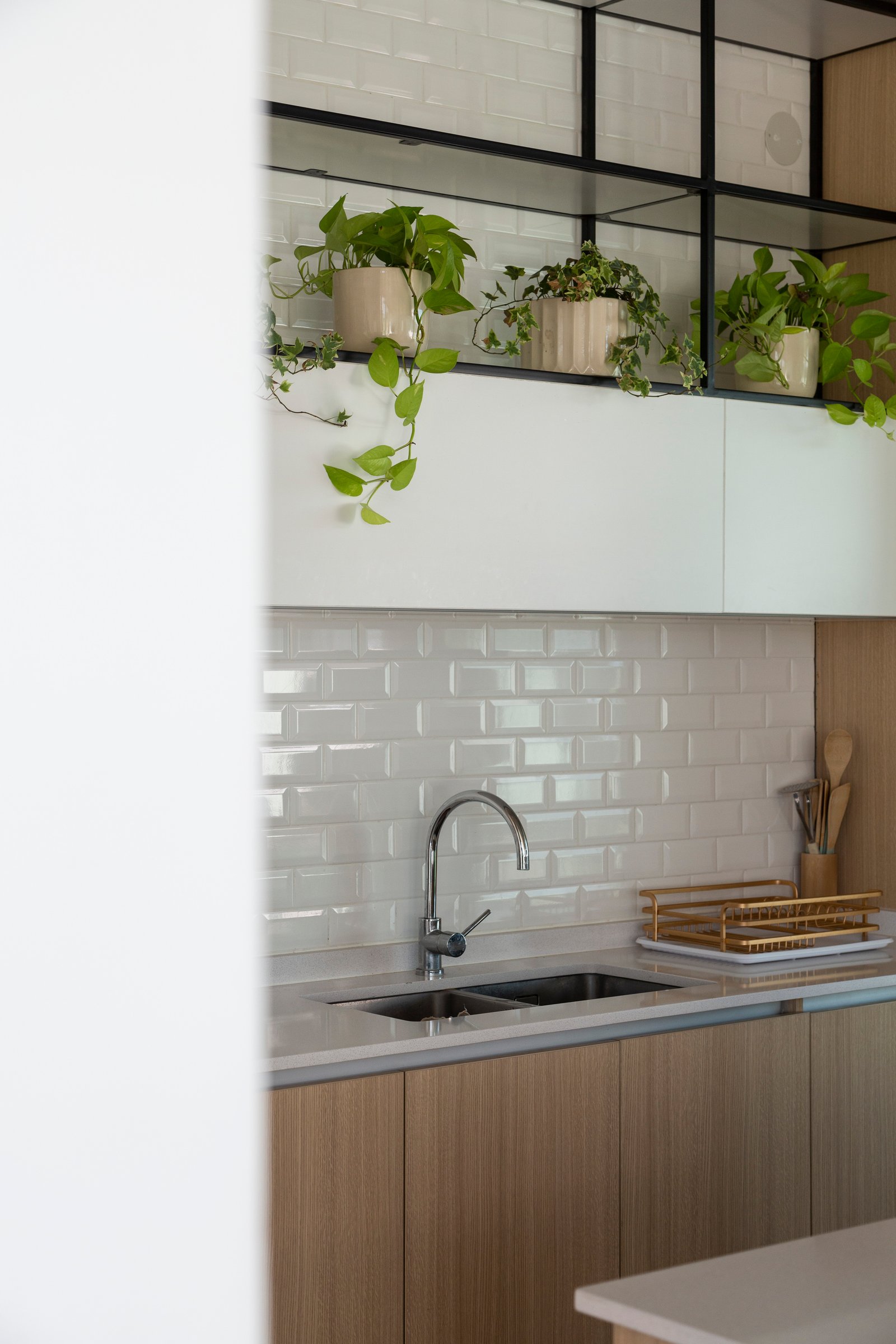 Cozinha moderna com azulejos brancos e armários de madeira — projeto Casa Cruz, por Grupo CRBN, em B2812 Exaltación de la Cruz