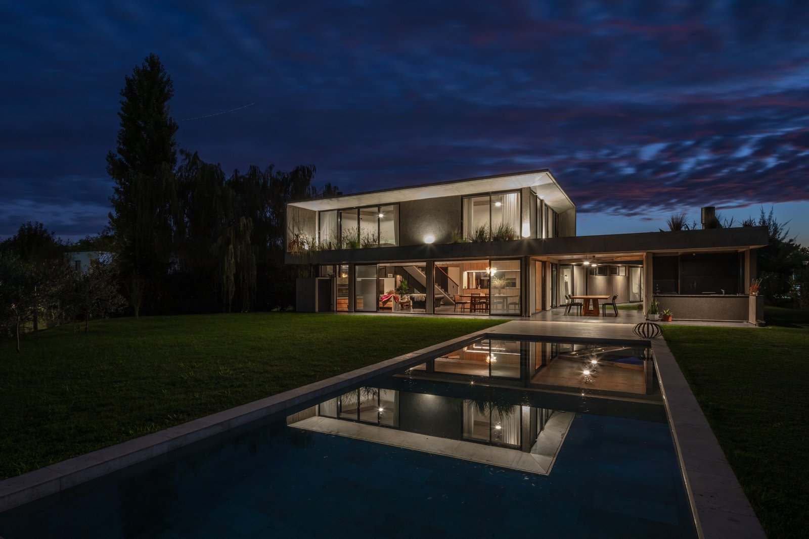 casa moderna con piscina infinita al atardecer — proyecto La Martona UF280, por BARBALACO ARQUITECTOS, en Provincia de Buenos Aires