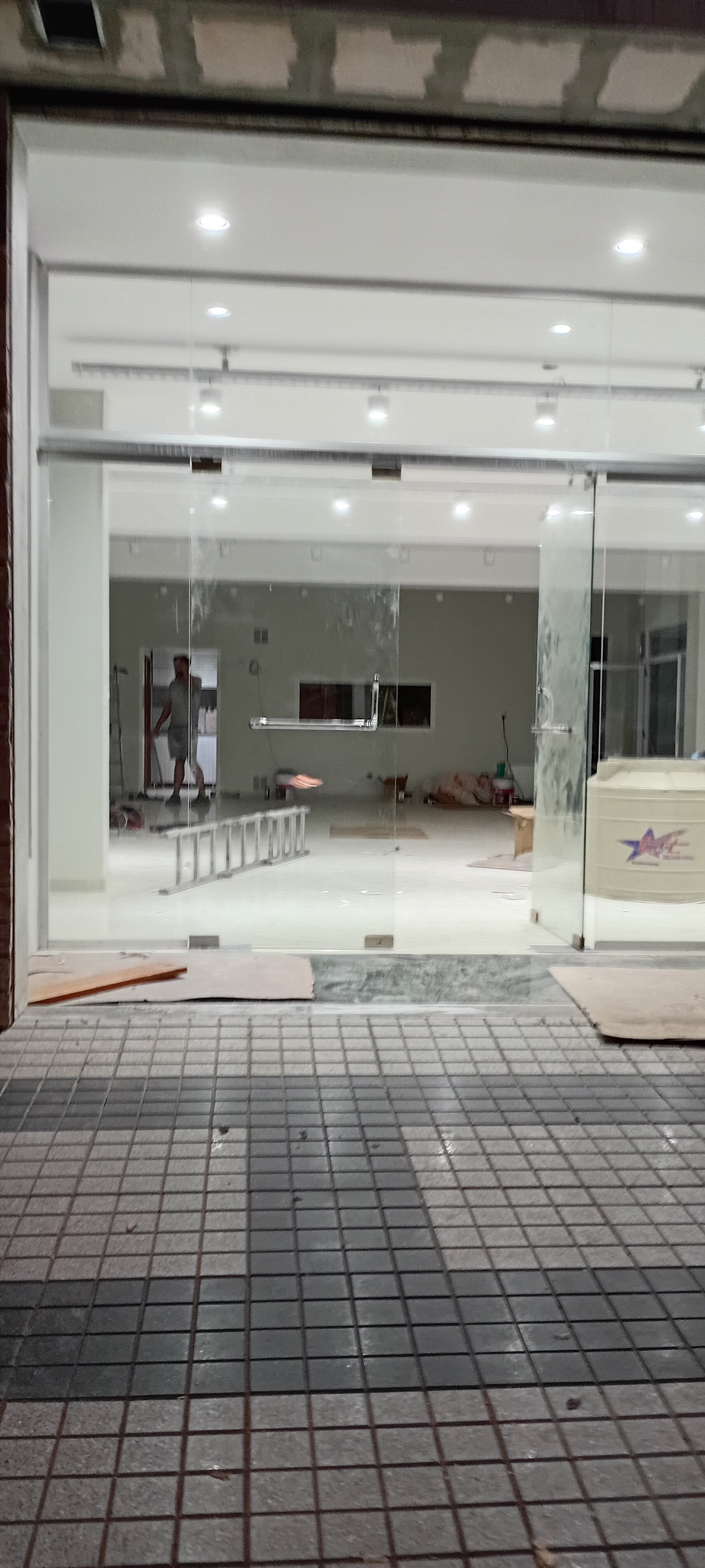 Local comercial en construcción con piso de cerámica y fachada de vidrio — proyecto MITRE SANITARIOS, por Yamil Cerna, en Tunuyán