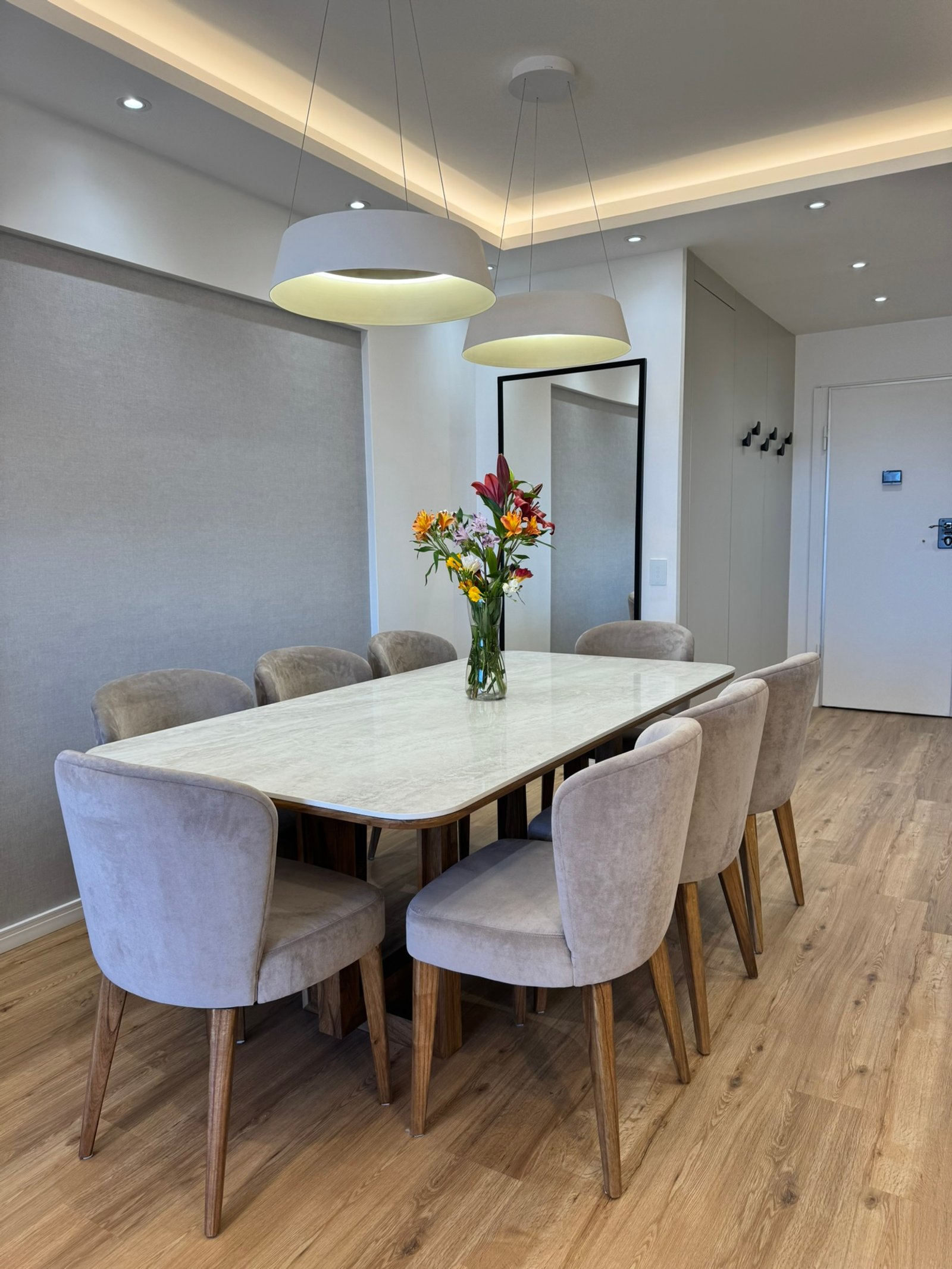 Comedor moderno y luminoso con mesa de mármol y sillas grises — proyecto Libertador II, por MDBK Arquitectura, en Núñez