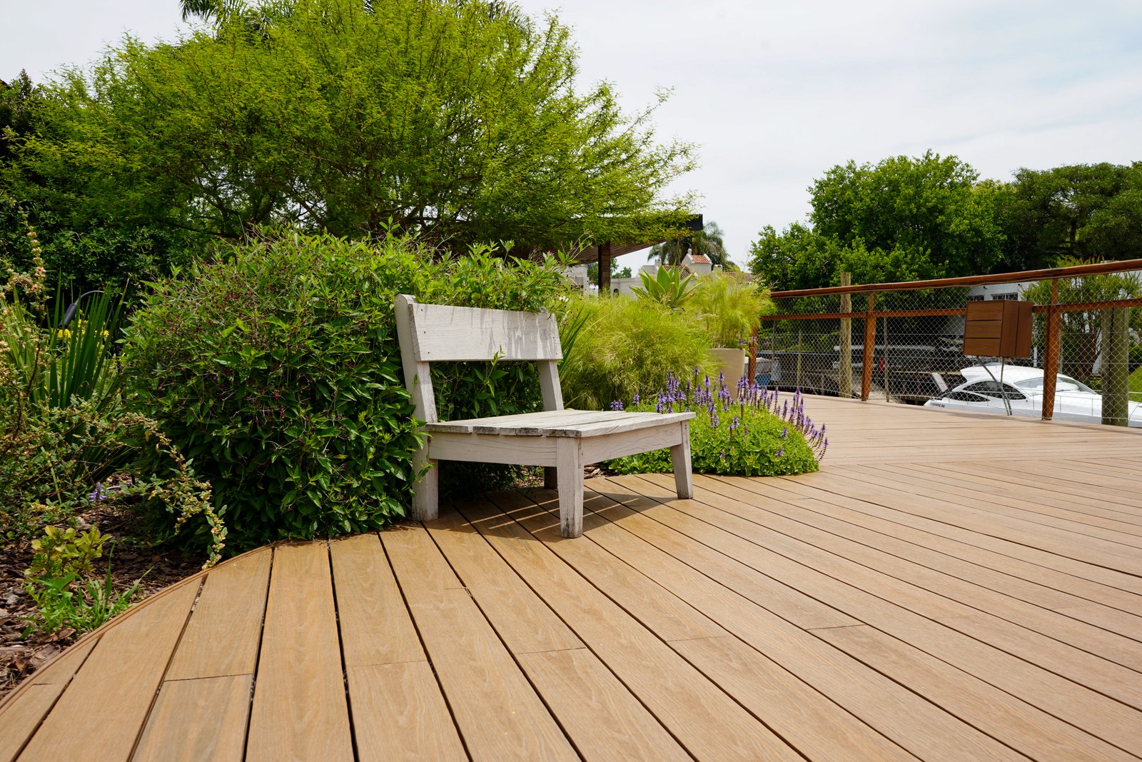 Terraza moderna con banco de madera y vegetación exuberante — proyecto Obra Boating, por lifecycle, en Náutico San Isidro - Punta Chica