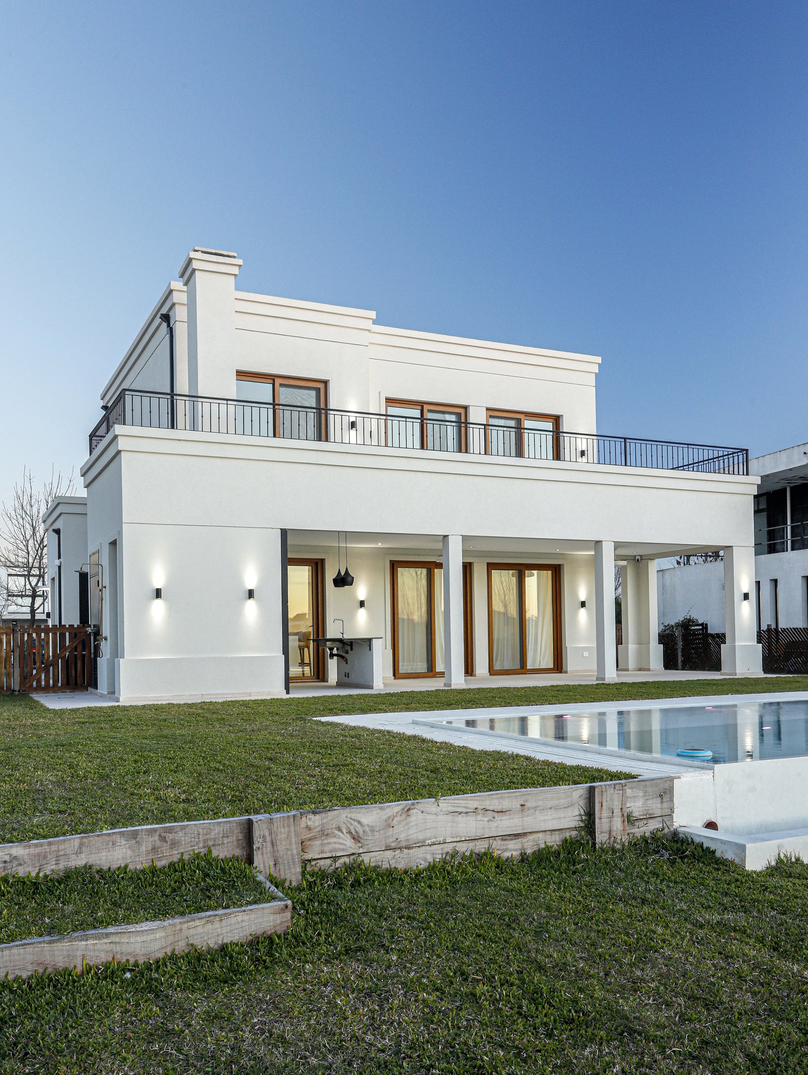Casa moderna blanca con piscina y césped apaisajado — proyecto Casa SS182, por EZ architects, en M3CV+6H