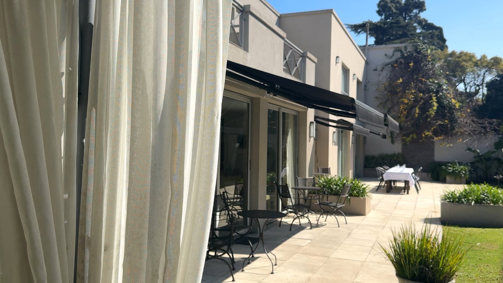 Pátio moderno com pérgola e móveis externos — projeto Villa Isidro Hotel Boutique & Spa, por Hermann Arquitectos, em San Isidro