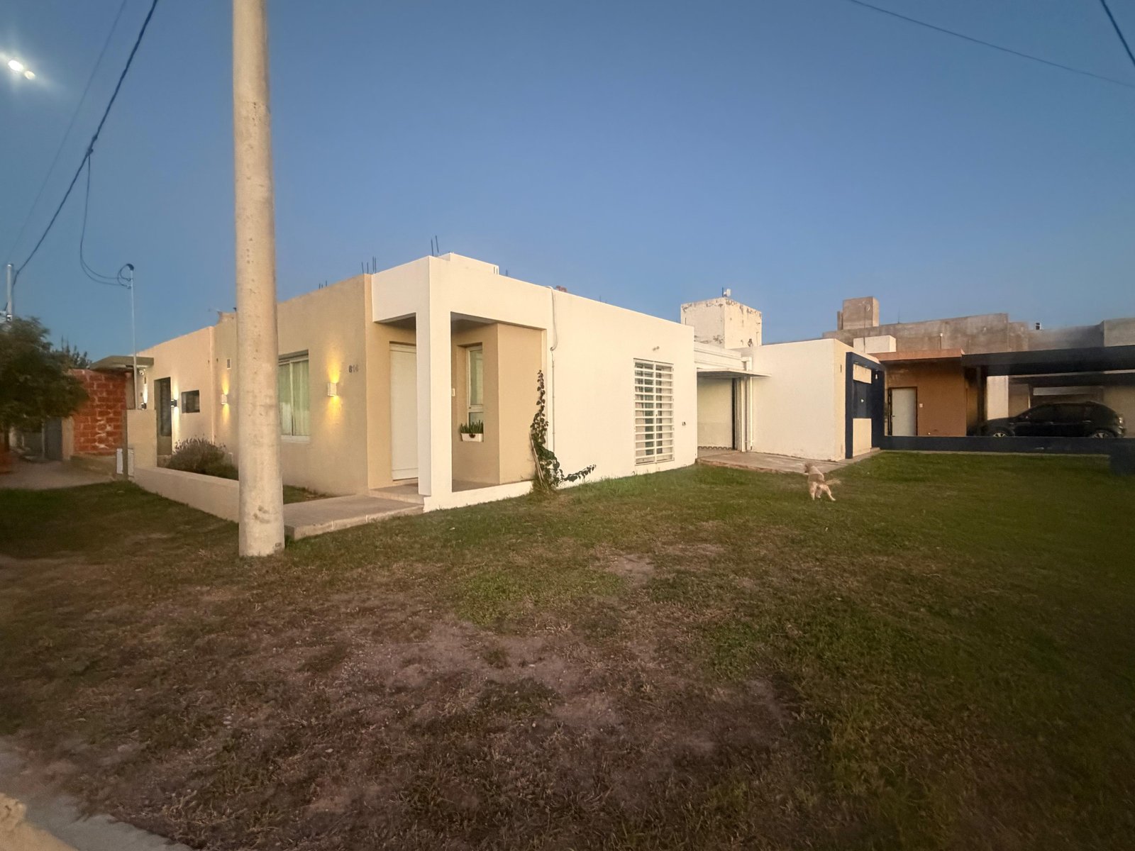 Fachada de casa moderna suburbana blanca con césped — proyecto FACHADAS JS, por Todo con A, en X5125 Monte Cristo