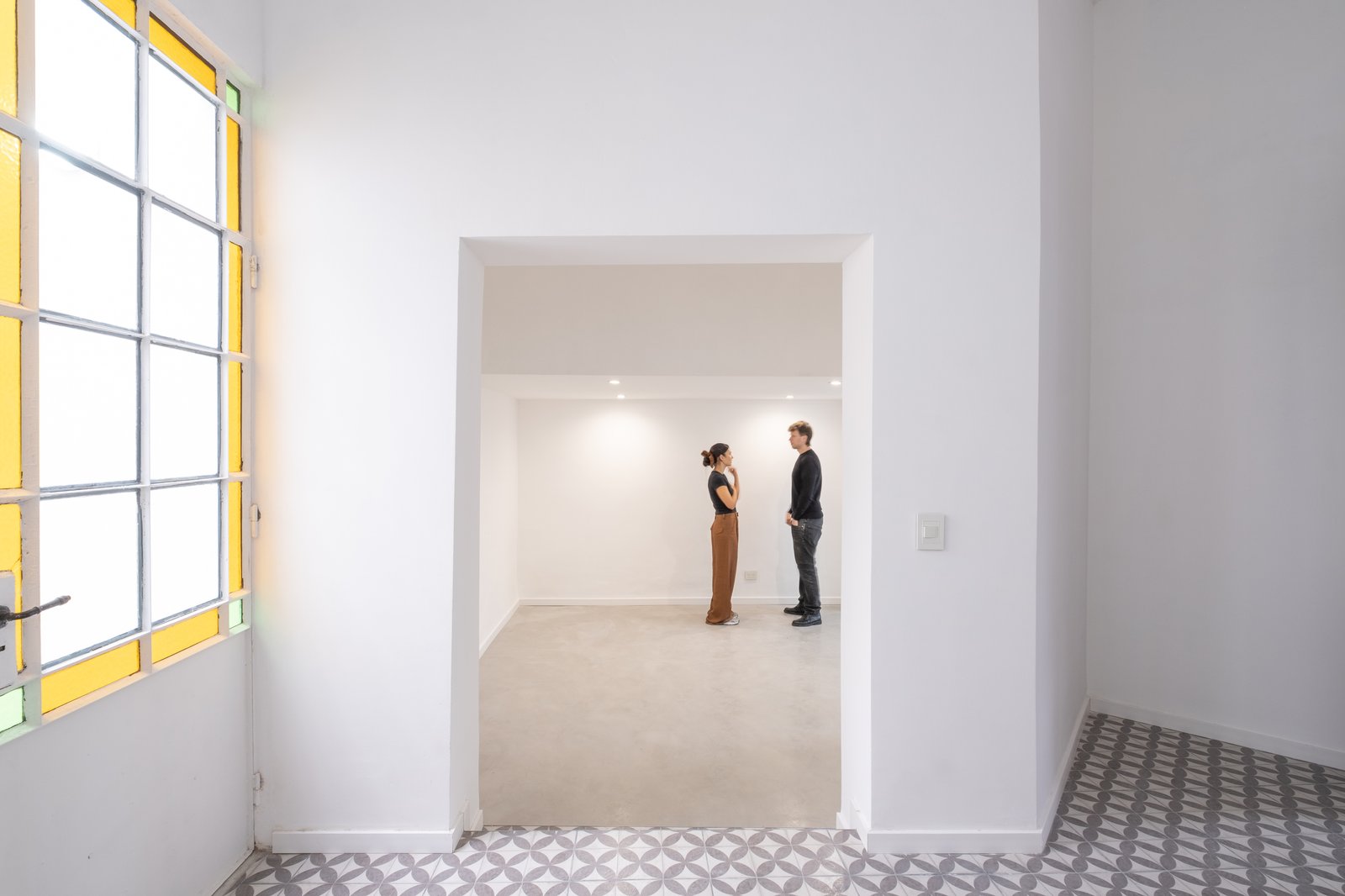 Espacio comercial moderno con arco y ventana grande — proyecto Casa Patio, por Herrera Ungaro, en San Cristóbal