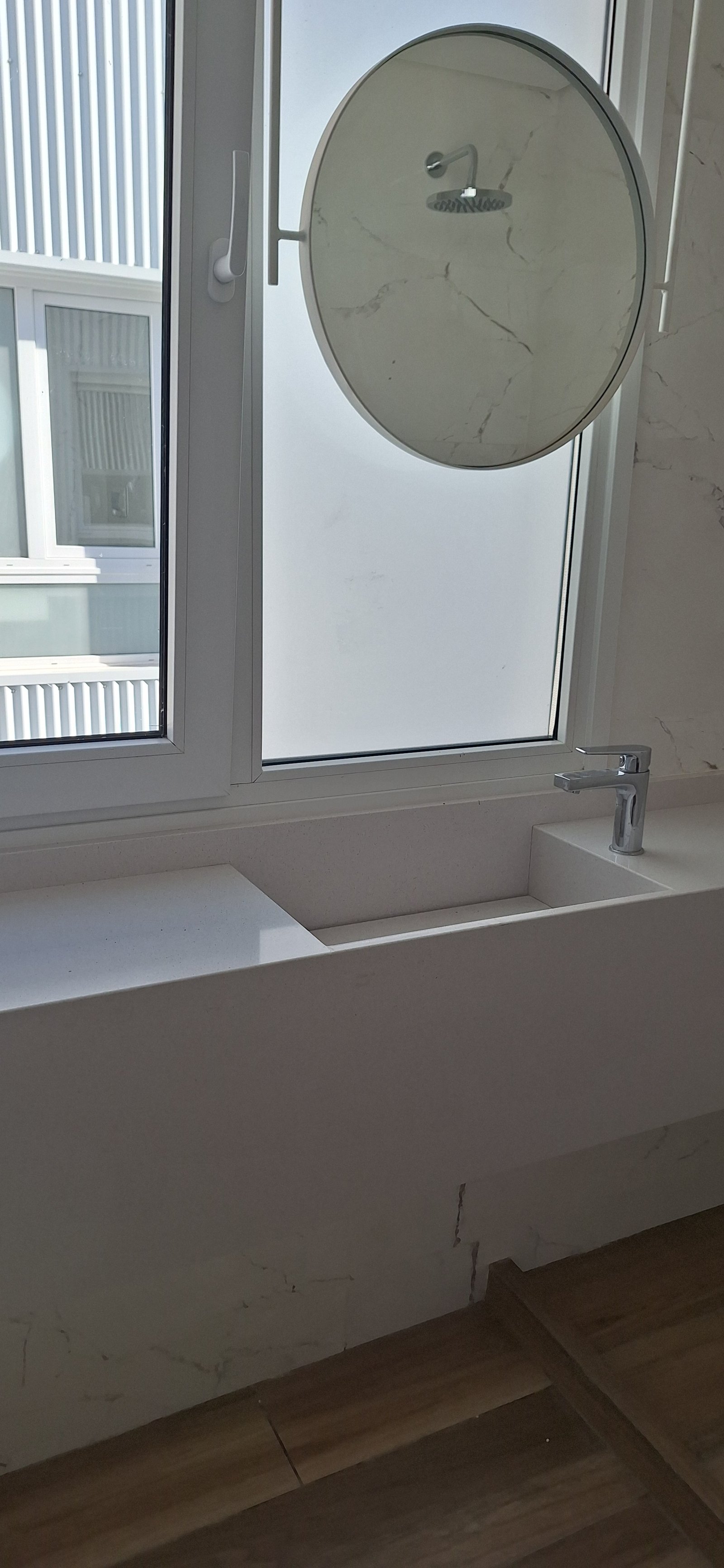 Baño moderno con lavabo de piedra integrado y espejo redondo — proyecto Edificio Escribano, por LW Lopez Wolder arquitectos, en Pasaje Escribano 66