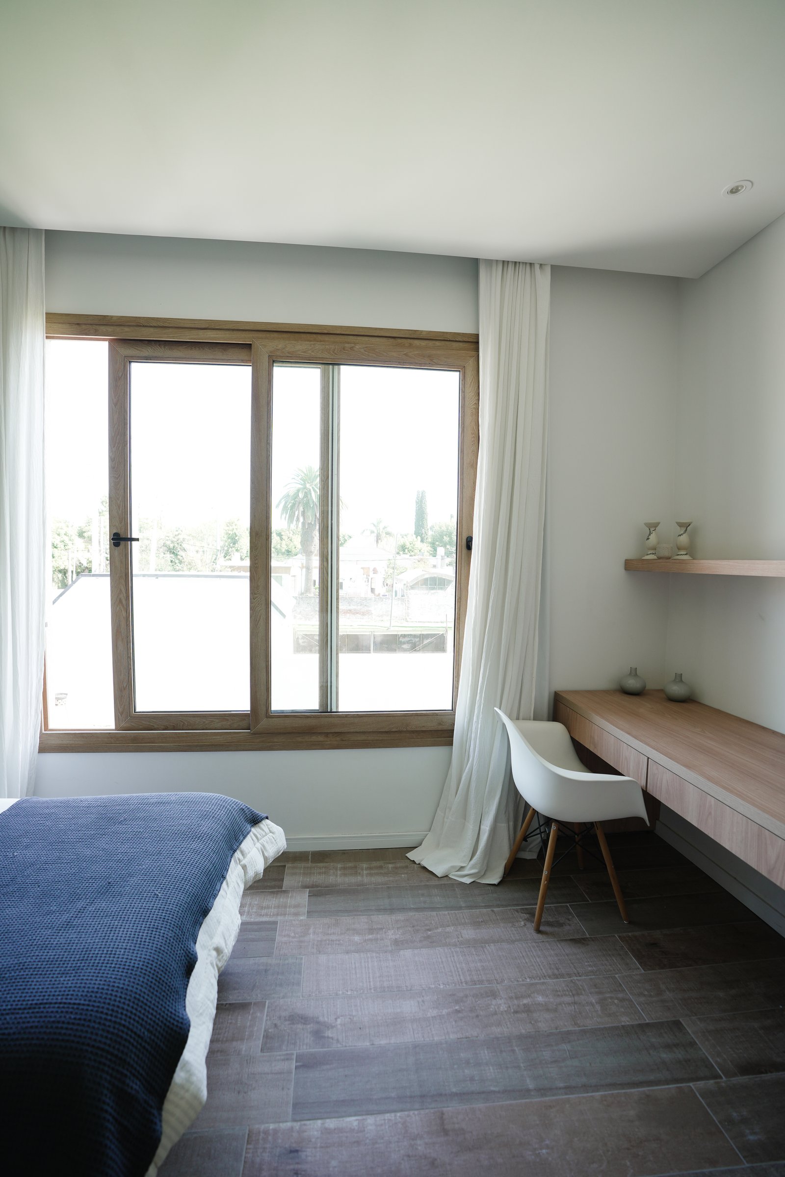 Dormitorio moderno con gran ventanal y escritorio minimalista — proyecto Habitaciones, por CASA1-TROMEN, en Bella Vista