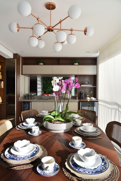 Comedor moderno con mesa madera, orquídeas y lampara cobre — proyecto Apartamento DE, por Giovana Ciacco, en Guarulhos