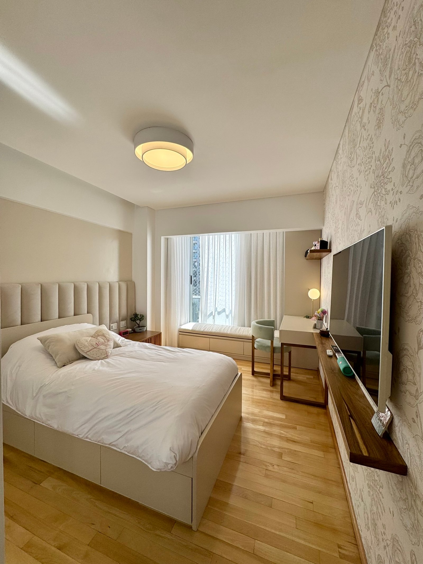 Quarto moderno com cama grande, mesa e TV. Paredes texturizadas e iluminação quente — projeto Mendoza, por MDBK Arquitectura, em Belgrano