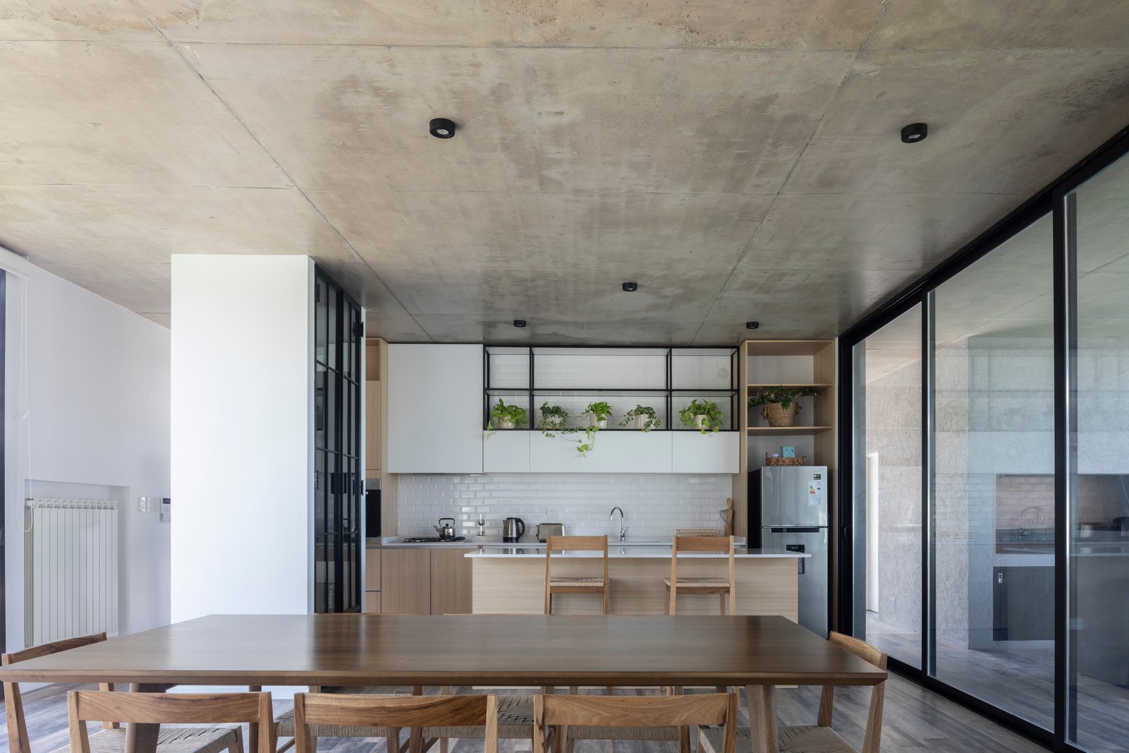 Cocina y comedor moderno con techo de hormigón expuesto y mucha luz natural — proyecto Casa Cruz , por Grupo CRBN, en B2812 Exaltación de la Cruz