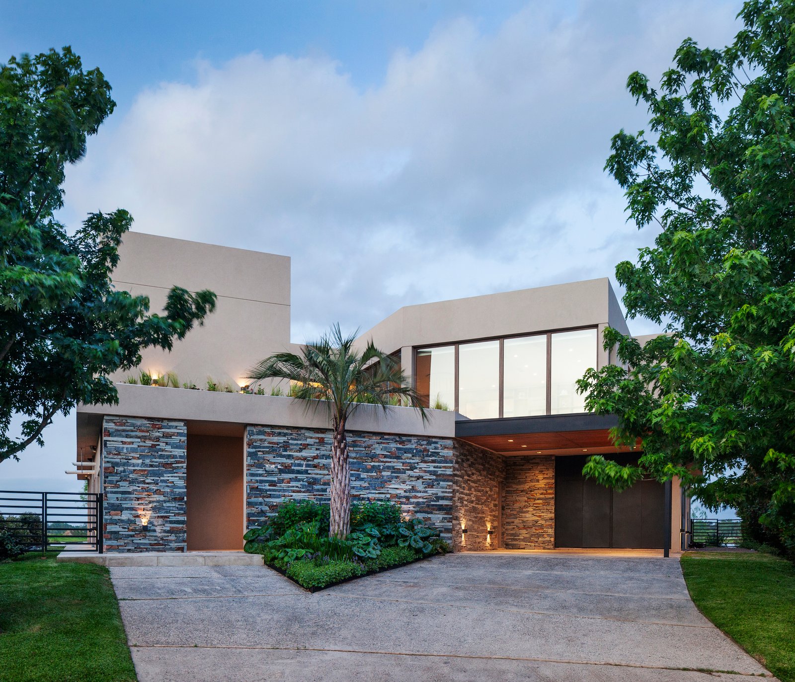 Fachada moderna geométrica con concreto y piedra — proyecto CASA M40, por A'PRIMA - Arquitectura Sustentable, en Unnamed Road