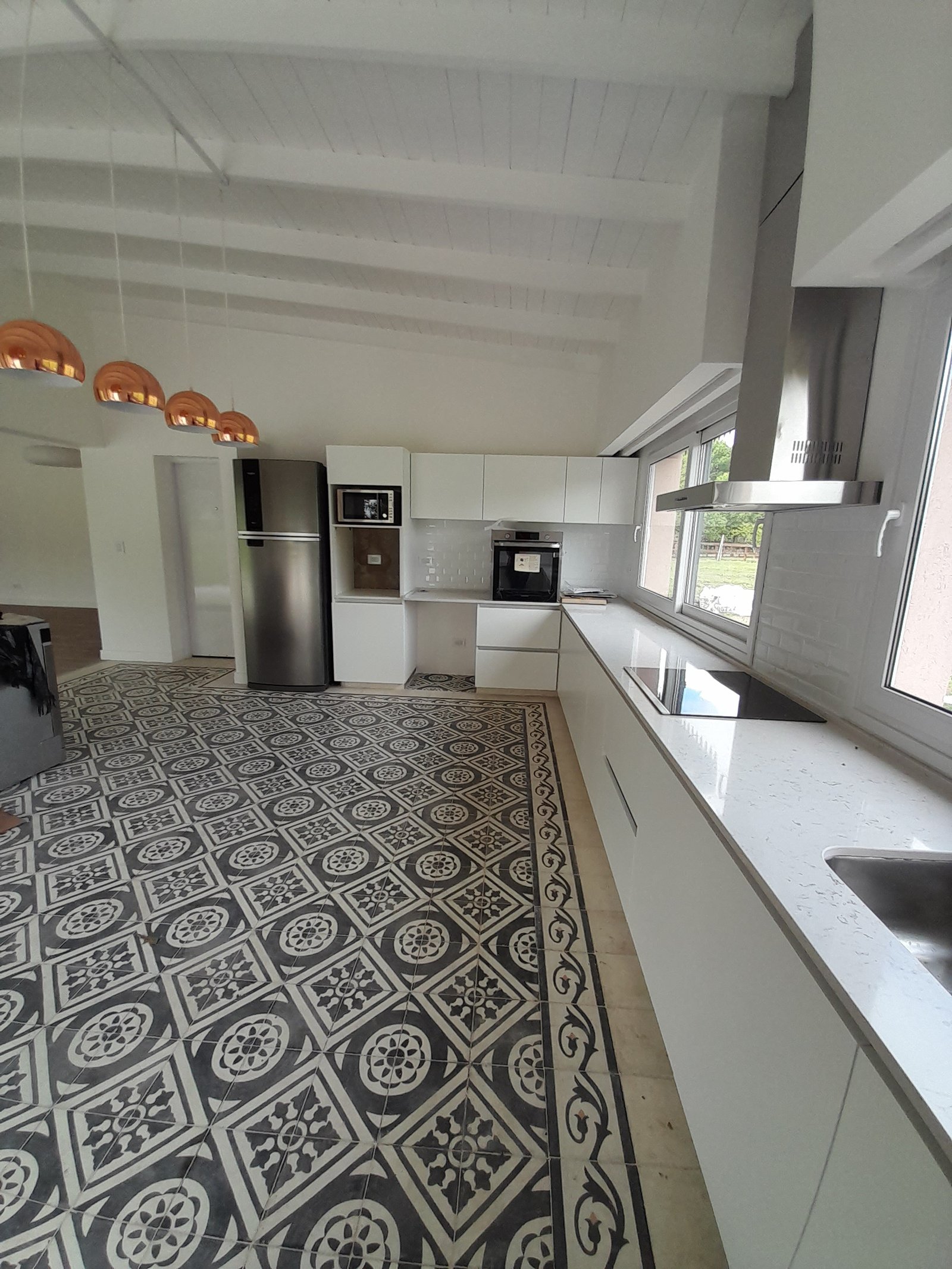 Cocina moderna con piso damero, vigas a la vista y luces cobre — proyecto Casa de Campo, por Estudio Fernandez Long & asoc., en San Andres de Giles