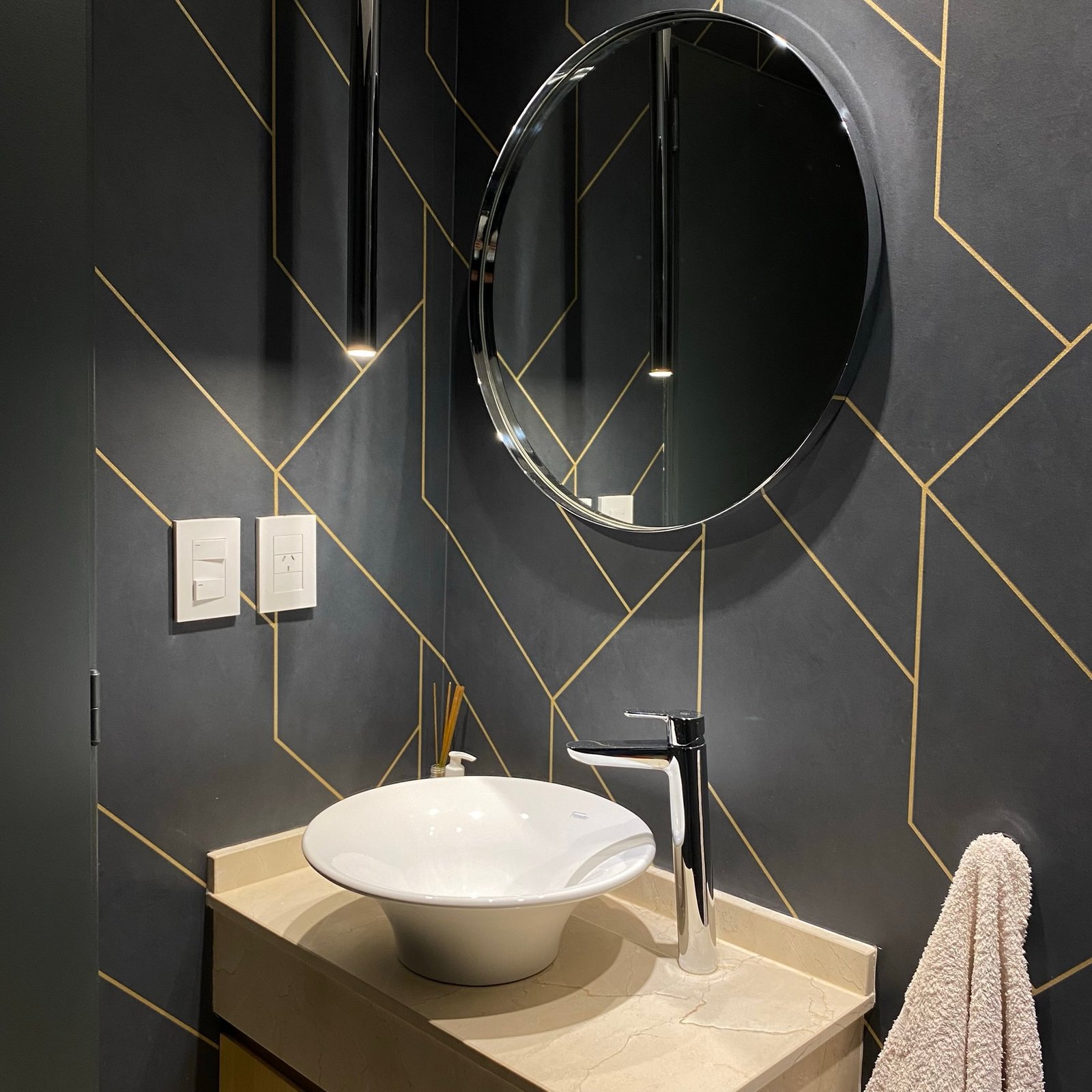 Banheiro moderno com papel de parede geométrico preto e dourado, cuba redonda e torneira cromada — projeto Padilla, por MDBK Arquitectura, em Villa Crespo