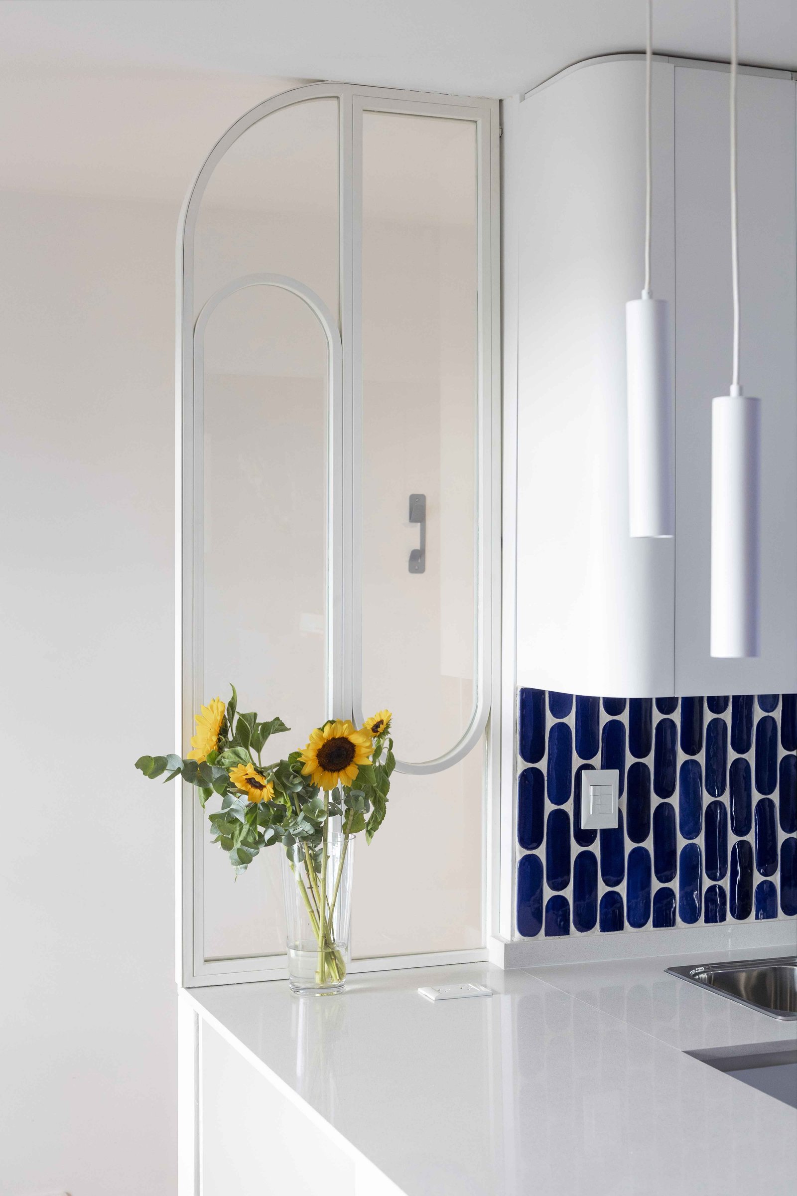 Cocina moderna con detalles curvos y azulejos ovalados azules — proyecto Julián Alvarez, por Bouré Studio, en Palermo