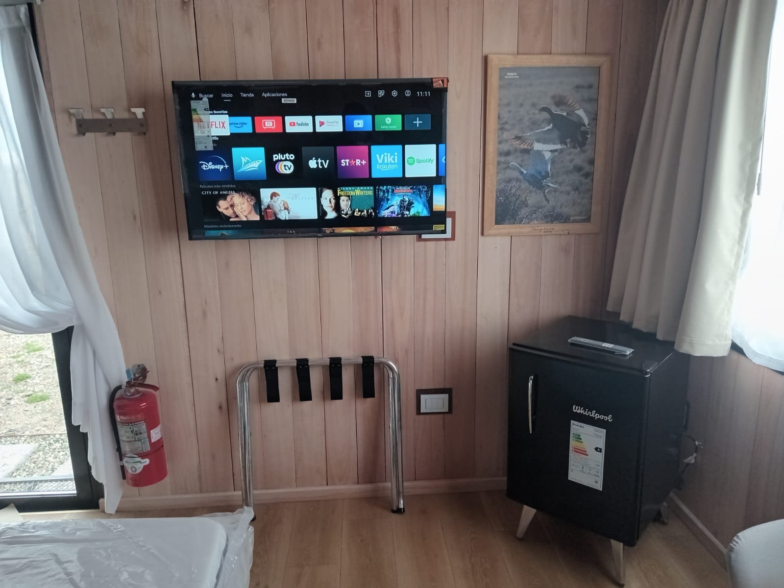 Sala rústica com paredes de madeira e TV — projeto Rio Gallegos Tiny Houses, por TROKEN, em Río Gallegos