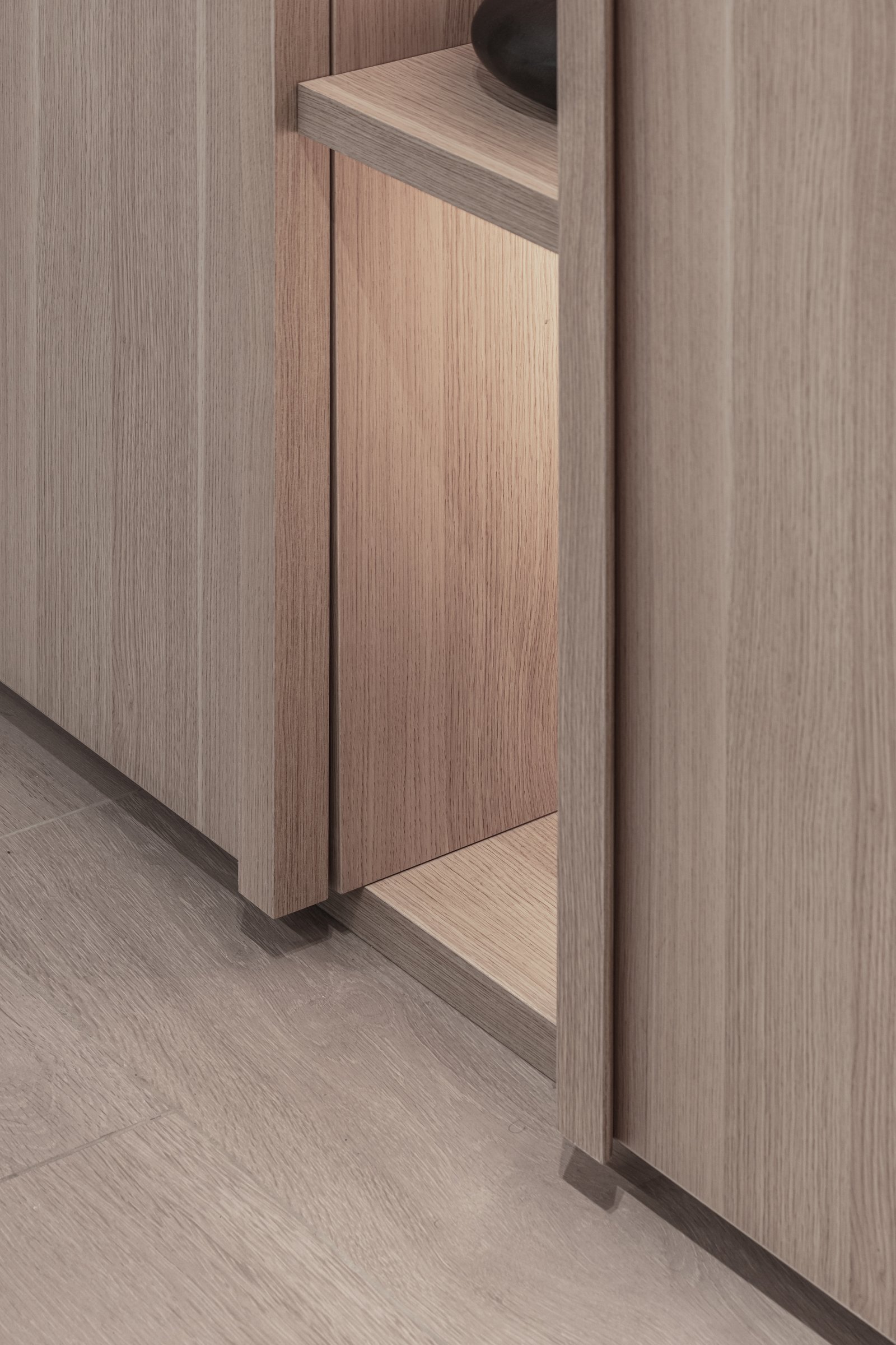 Detalhe de móvel de madeira com iluminação embutida e prateleira — projeto Eslovenia | Pied-à-terre | Lucia Quinteros, por Ren Studio, em Cdad. Autónoma de Buenos Aires
