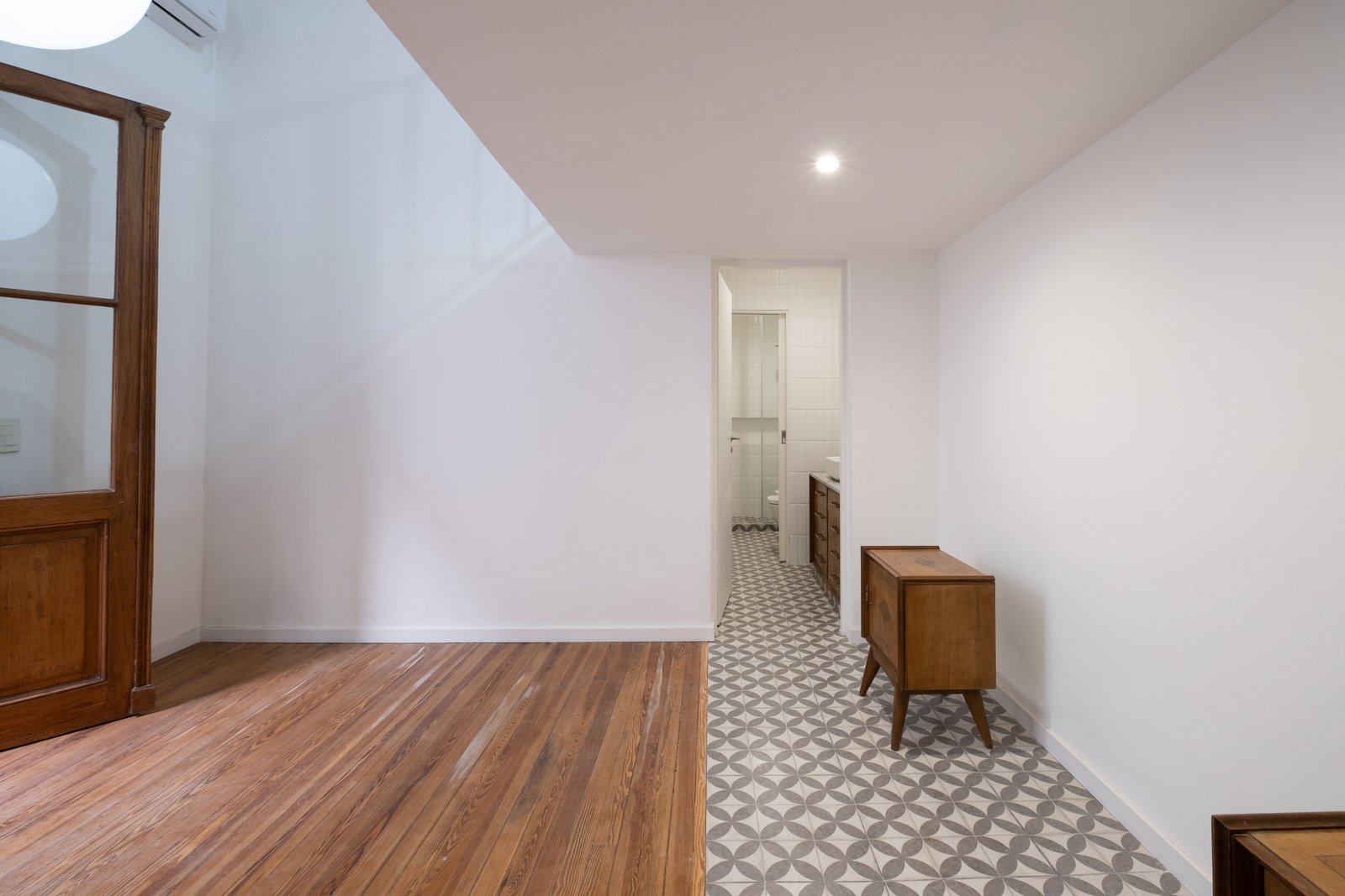 pasillo con transición de pisos y mueble vintage — proyecto Casa Patio, por Herrera Ungaro, en San Cristóbal