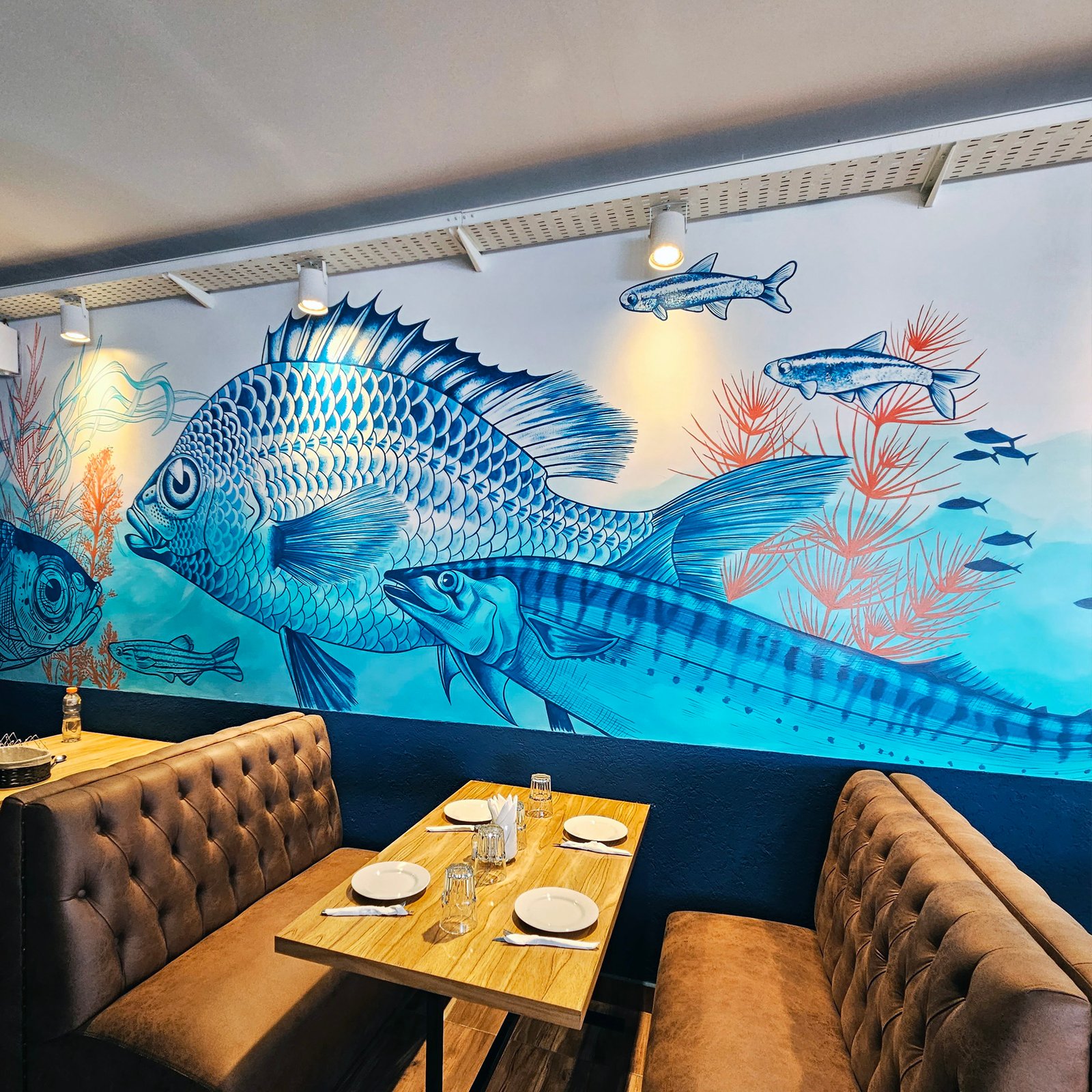 Comedor con mural de peces y asientos tapizados — proyecto Chicha cocina peruana., por UN.MURAL, en Comisionado José Indart 2699
