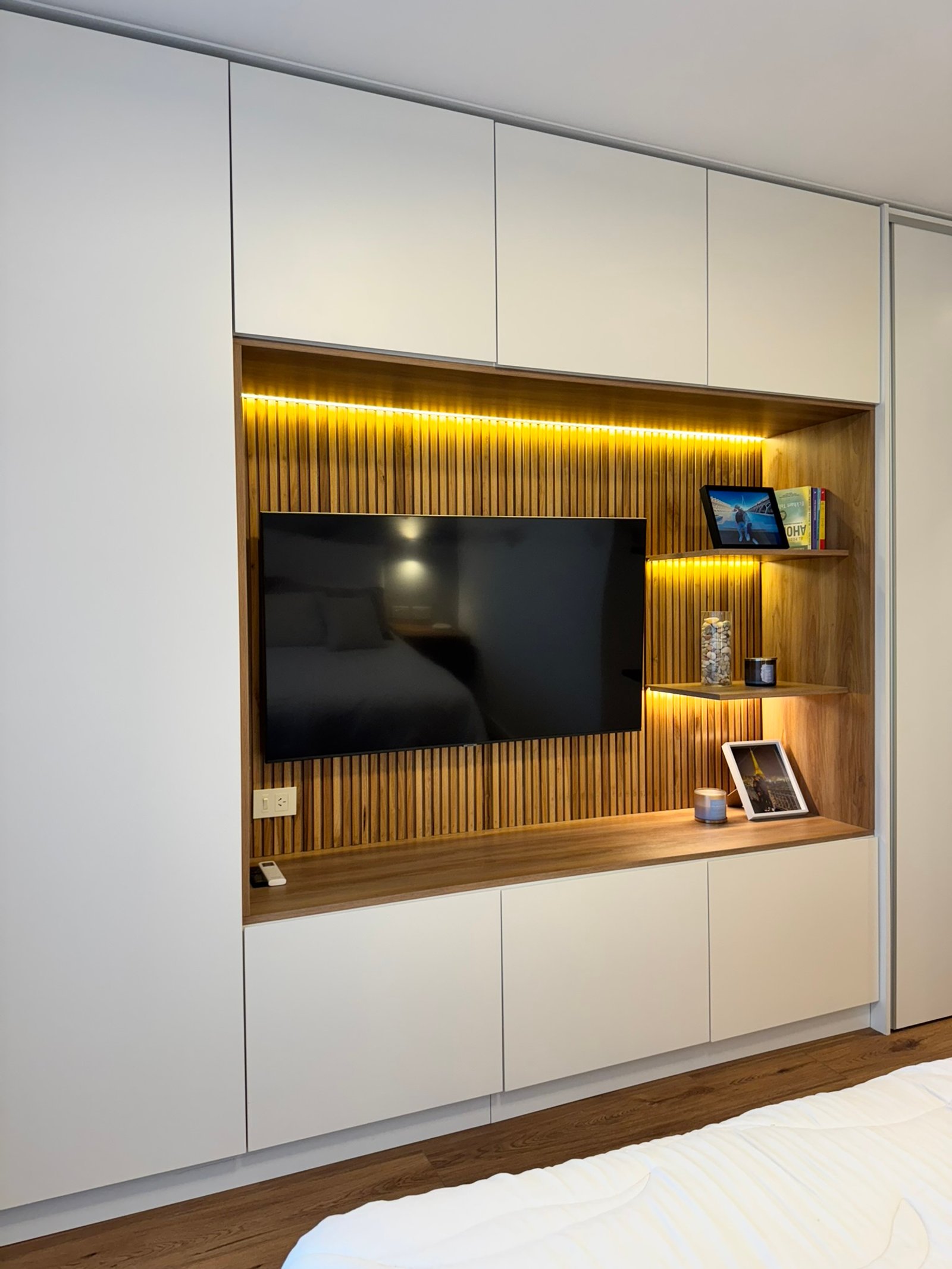 Quarto moderno com parede de ripas de madeira e iluminação embutida — projeto Ciudad de la Paz, por MDBK Arquitectura, em Belgrano