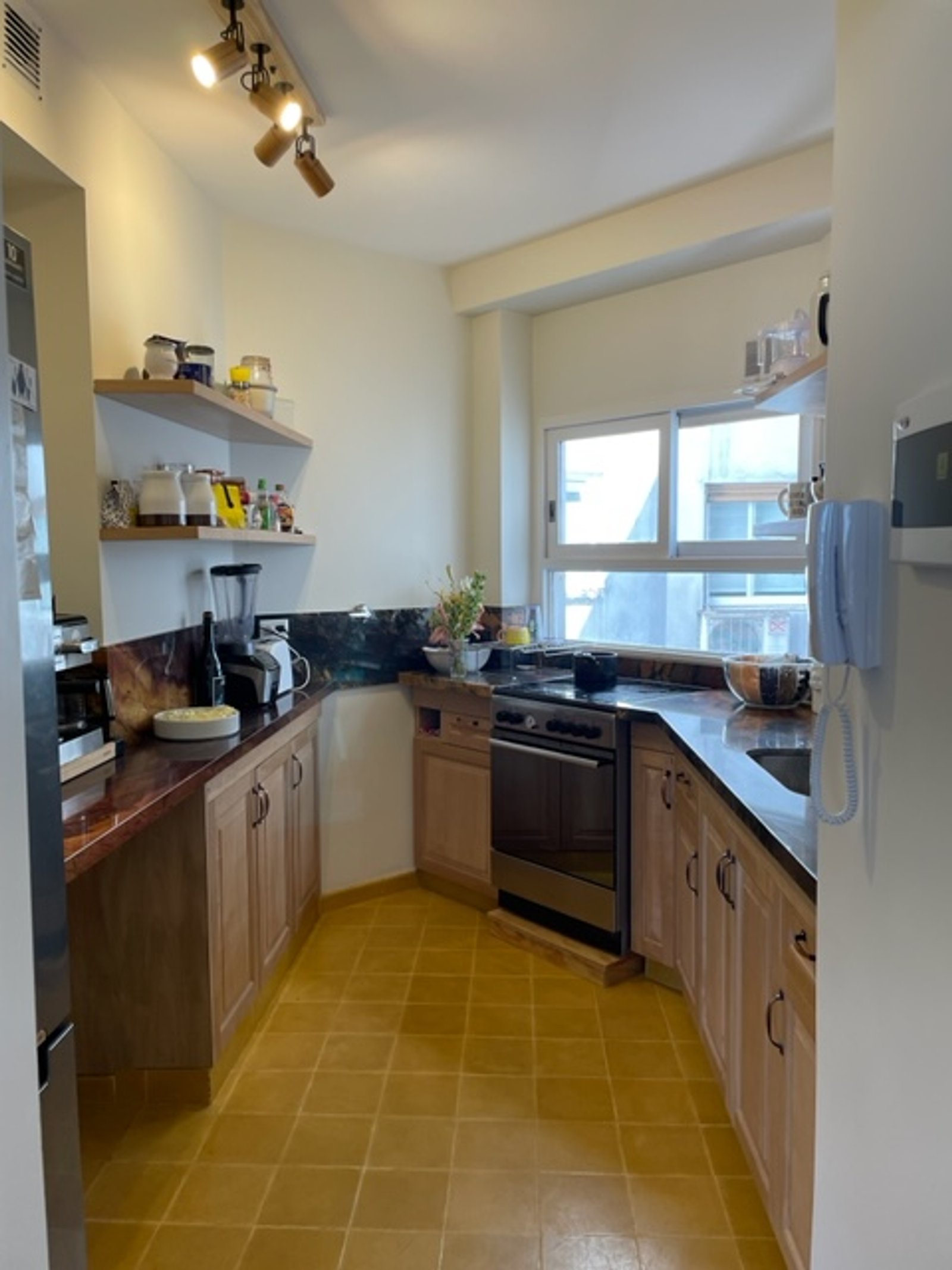 Cocina moderna con muebles de madera y mesada de piedra — proyecto Chenaut , por Estudio NET Arquitectura , en Av. Gral. Indalecio Chenaut 1739