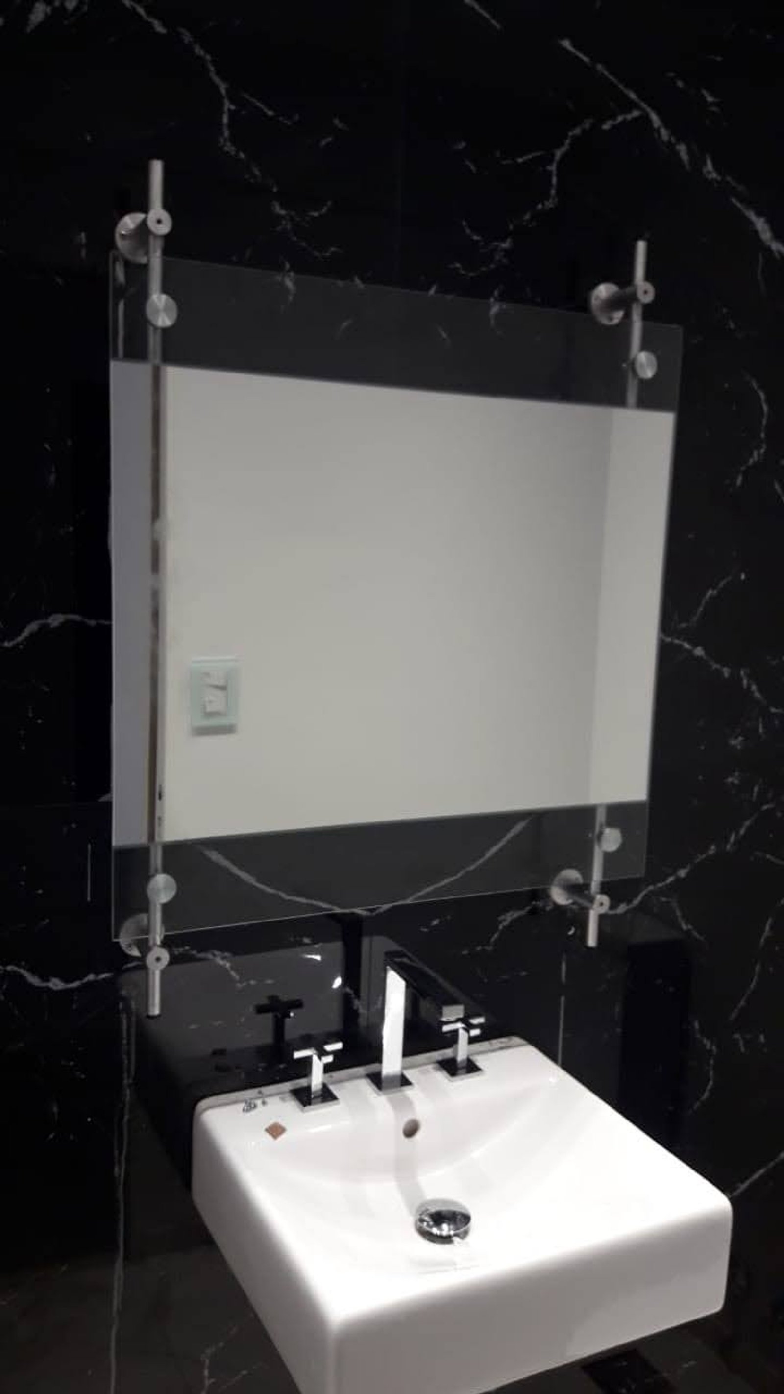 Baño moderno con espejo grande y lavabo de mármol negro — proyecto Espejo sin nitrato de plata con barrales pegados laser uv, por Cristalcenter, en Villa Devoto