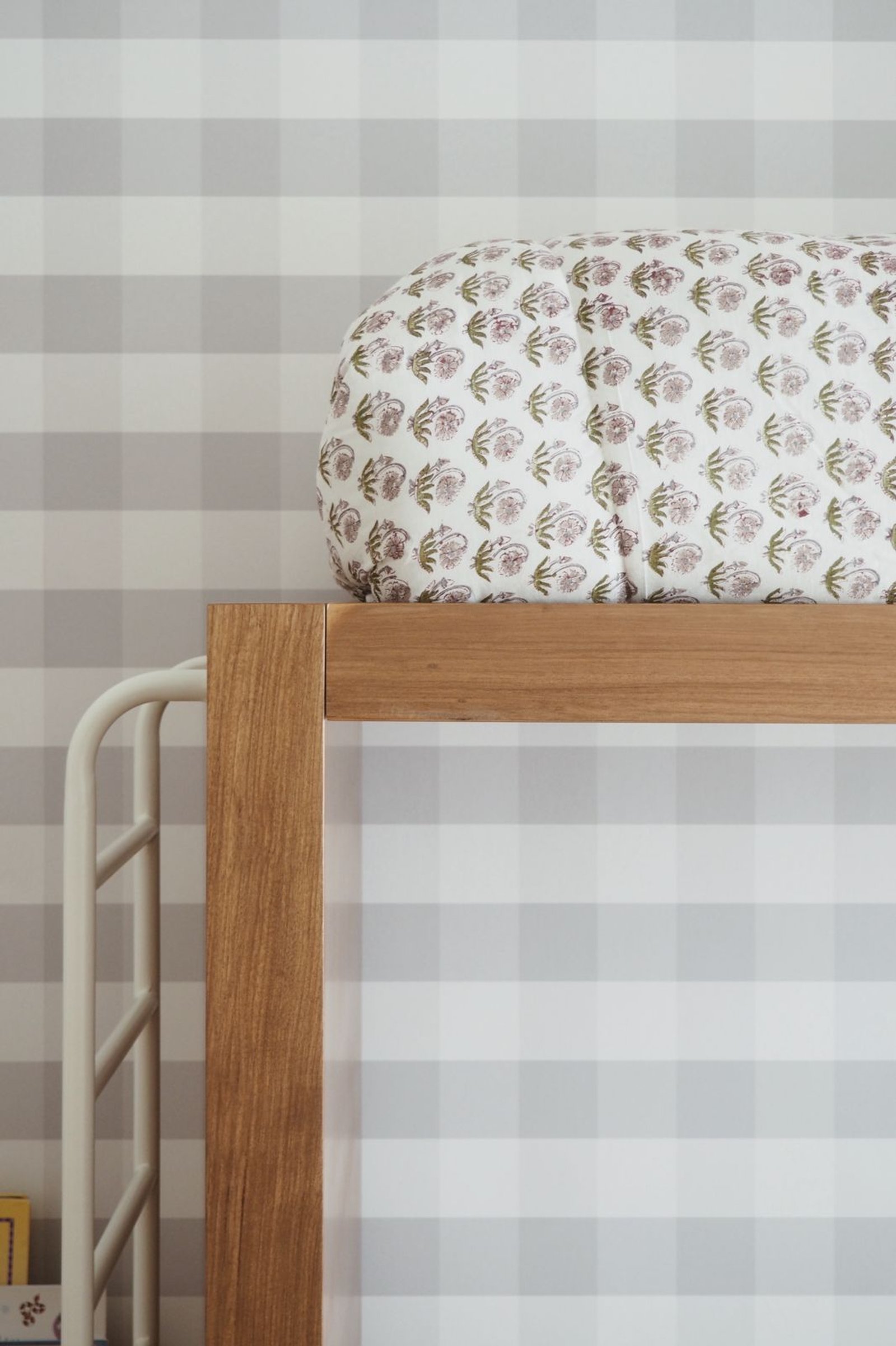 Cojín floral y cama con detalles de madera y metal, fondo a cuadros — proyecto JUNÍN, por APATHEIA, en Buenos Aires