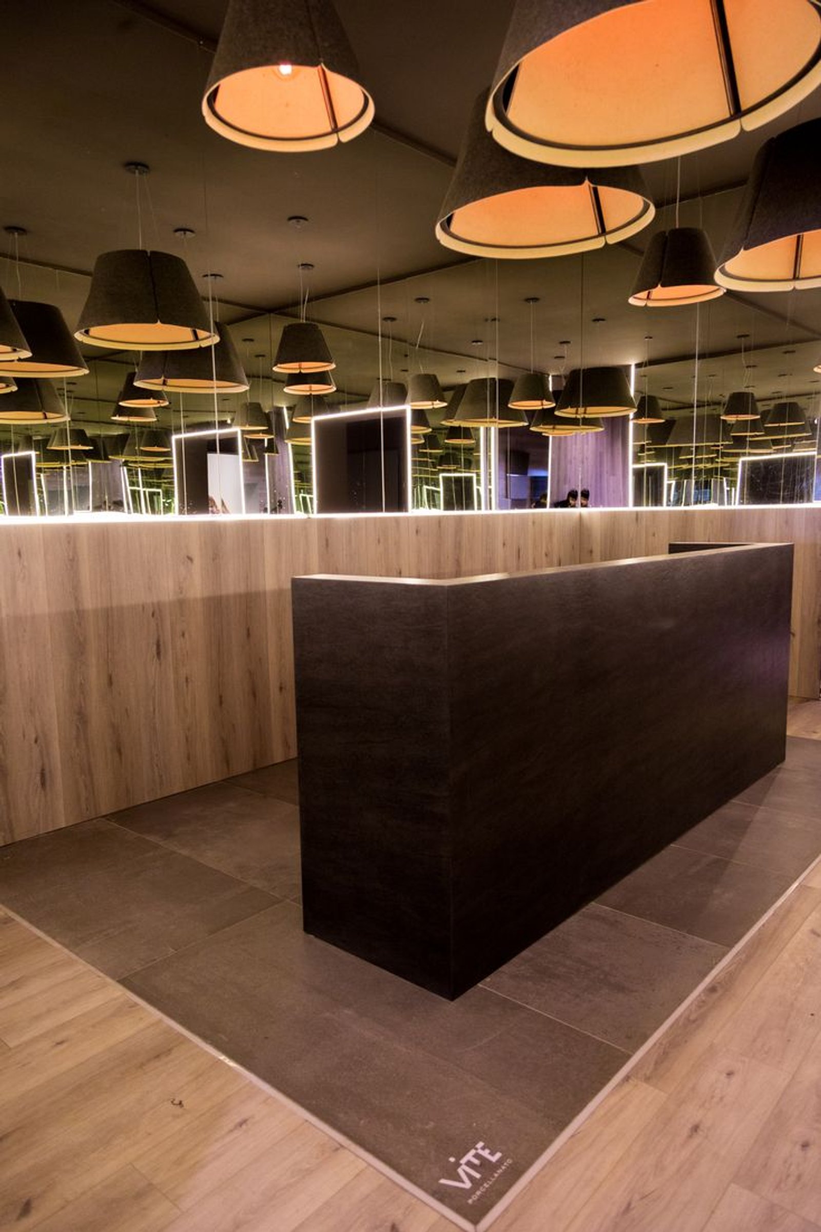 interior moderno de local comercial con escritorio y luces colgantes — proyecto Casa Foa Circulo Olivos 2019, por Vite Porcellanato, en La Lucila