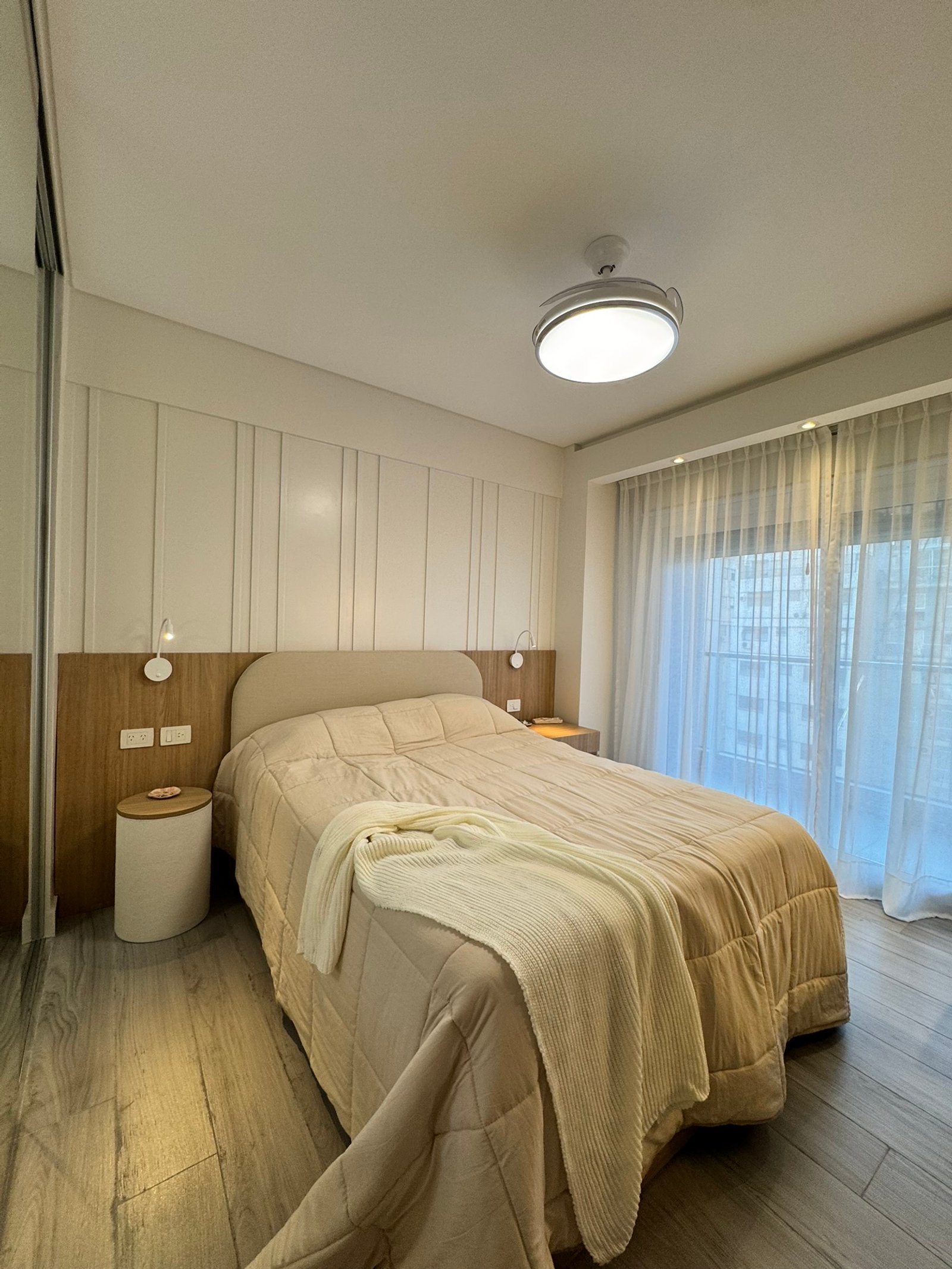 Dormitorio moderno con cama grande y mesas de luz, paredes paneladas — proyecto Cerviño, por MDBK Arquitectura, en Palermo
