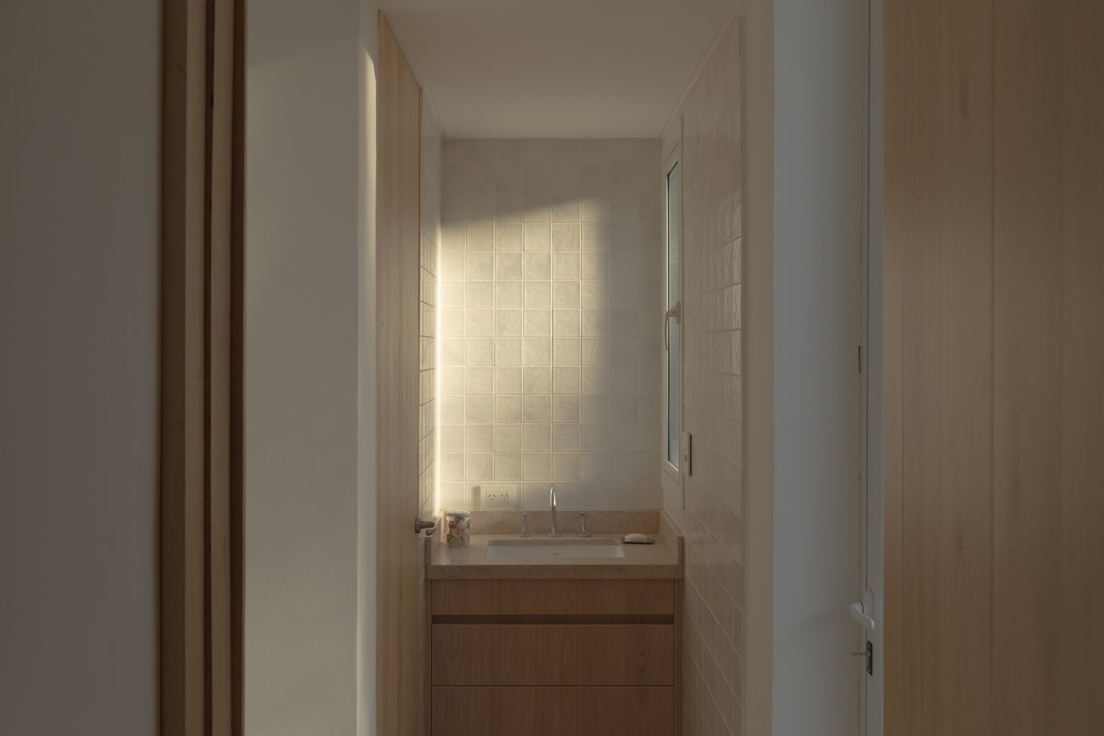Banheiro moderno com luz natural e bancada de madeira — projeto Vivienda CCE, por ONA - Oficina Nómada de Arquitectura, em M5505 Chacras de Coria