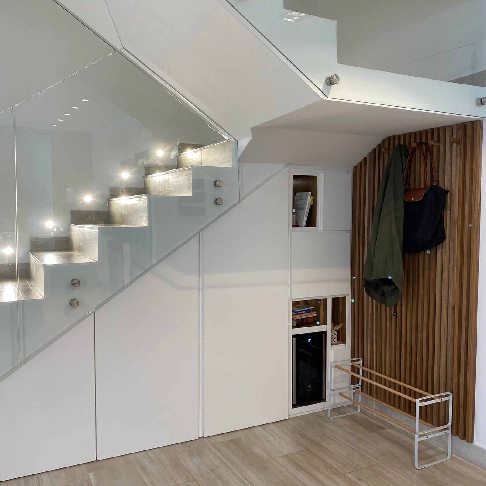 interior moderno con escalera flotante y almacenamiento bajo escaleras — proyecto Nicolas Repetto, por MDBK Arquitectura, en Caballito