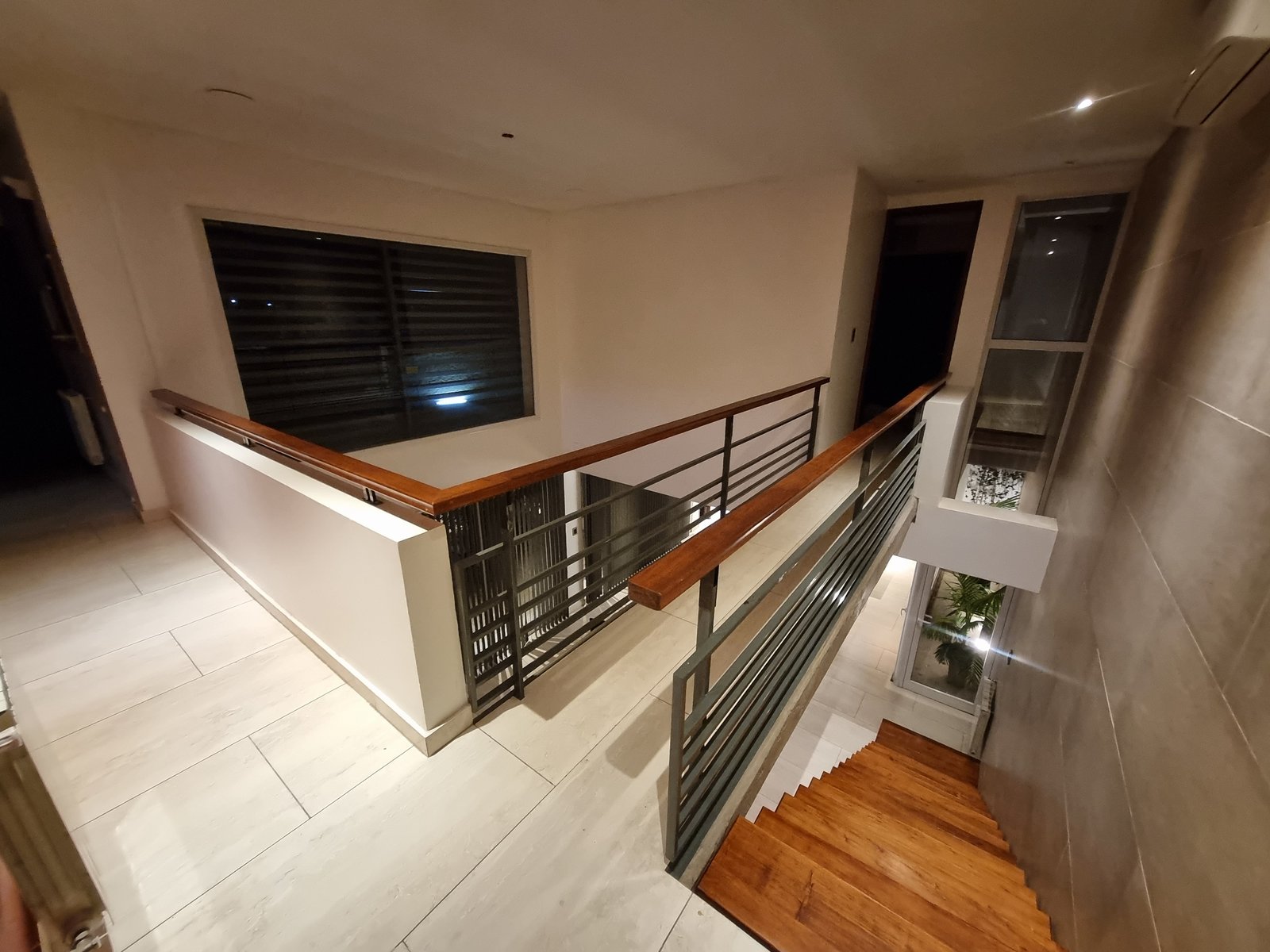 escada moderna com corrimão de madeira e metal — projeto CASA ML, por ML ARQUITECTURA / ARQ. MARIANO LEOTTA, em J5400 Concepción