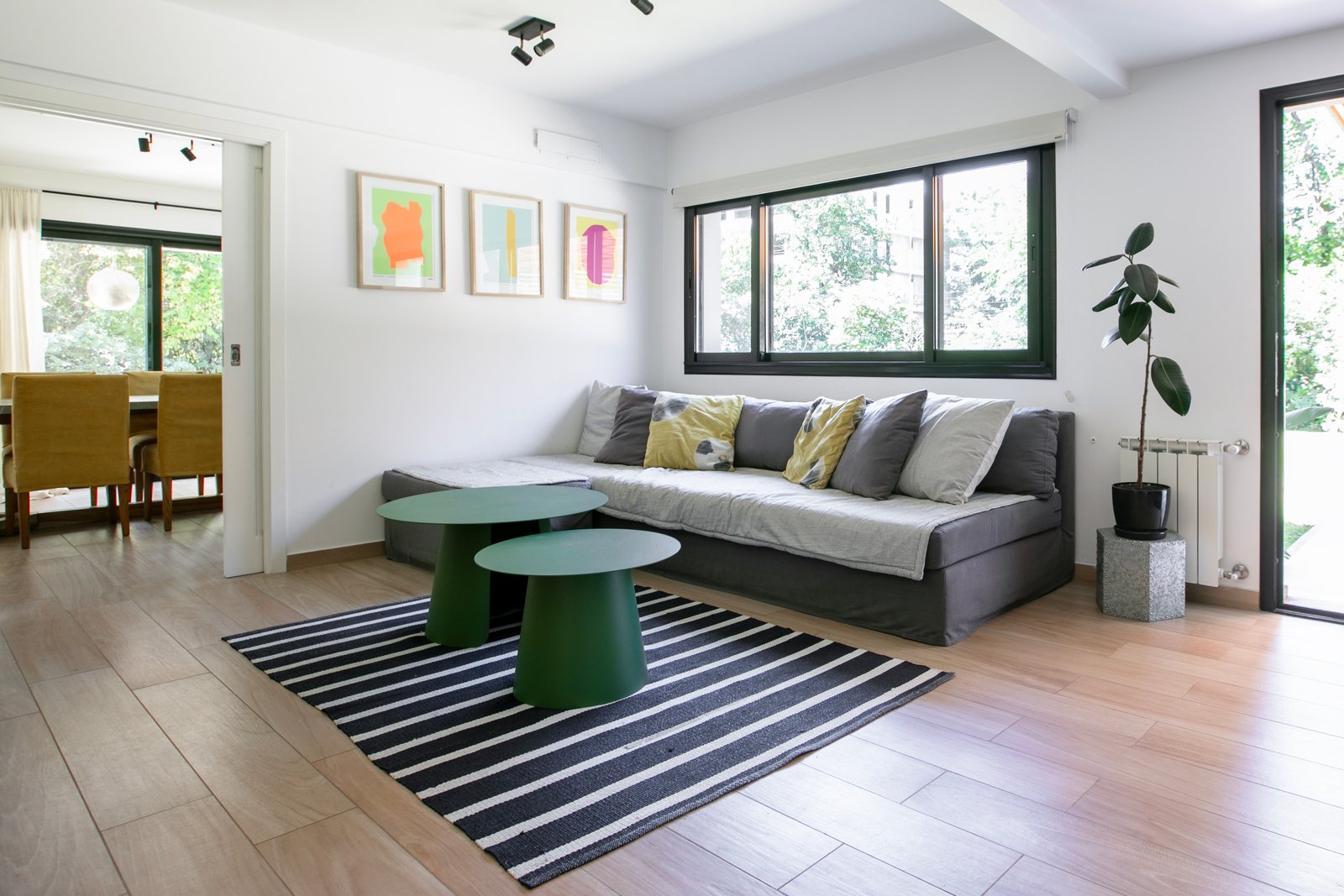 Living moderno con sofá gris y mesas de centro redondas — proyecto PROYECTO CAT COURREGES, por ILVA, en Provincia de Buenos Aires