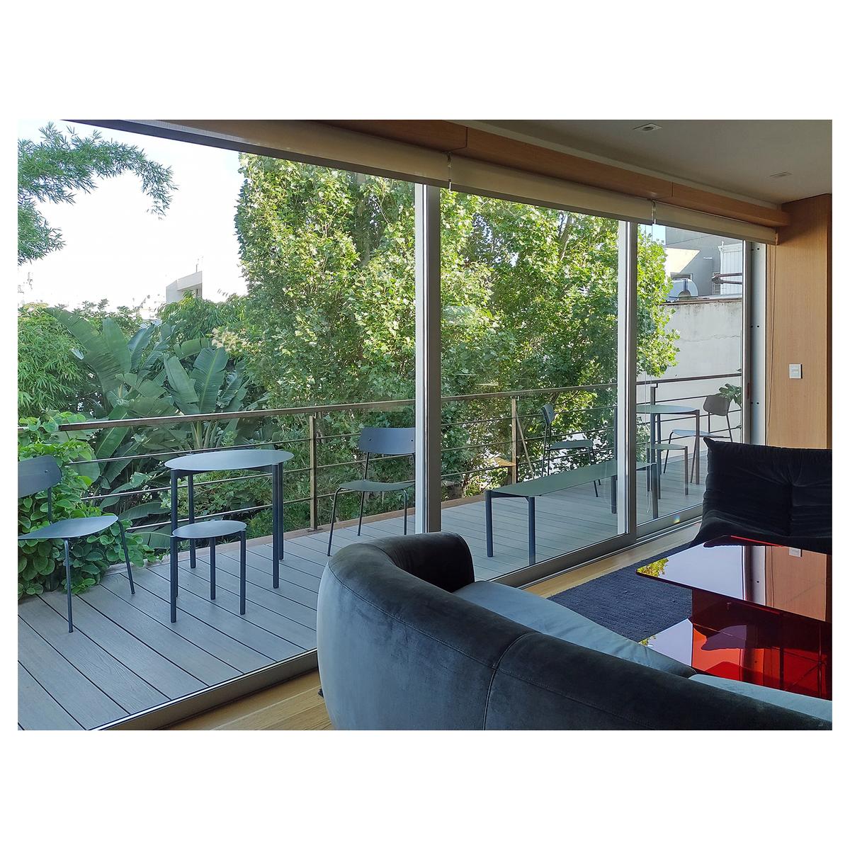 Varanda moderna com sofá curvo e vista para floresta exuberante — projeto Office space for The Movement, por Michelo Guzzo, em Buenos Aires