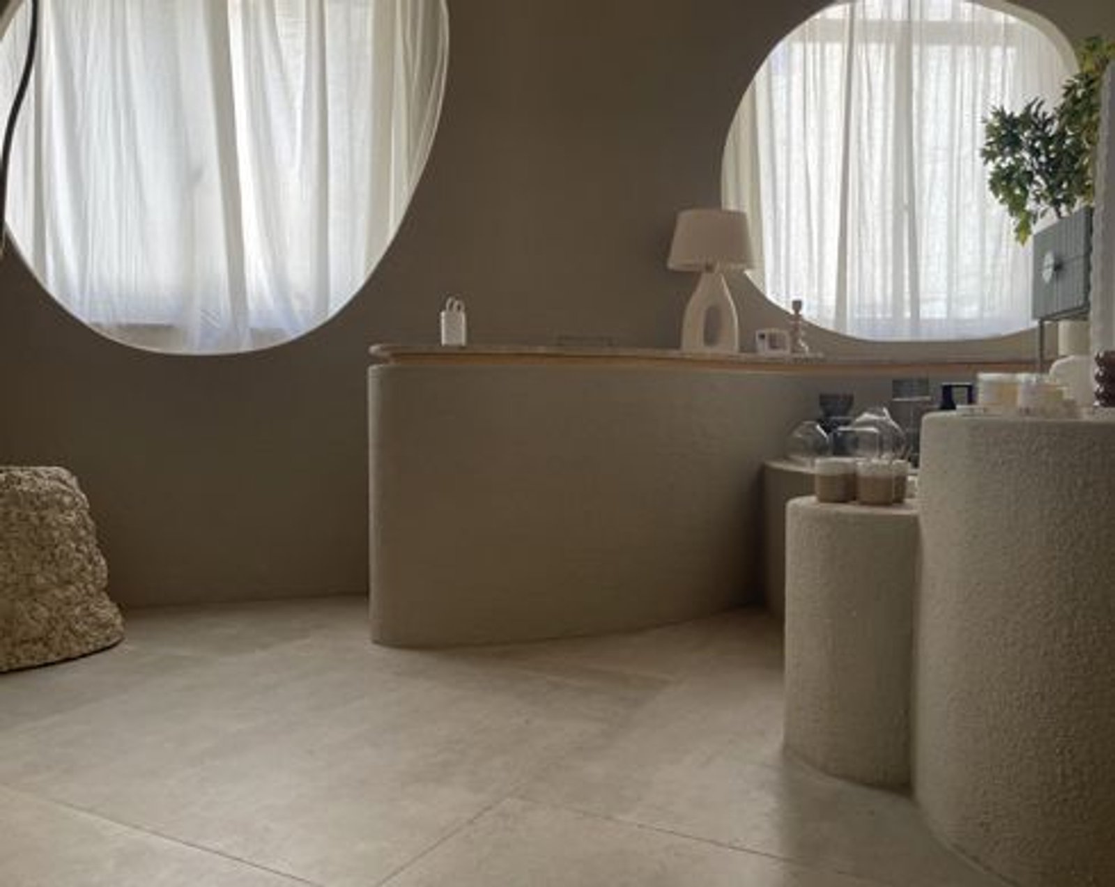 Espacio comercial minimalista con mostrador curvo y cortinas vaporosas — proyecto Casa Foa Retiro 2022, por Vite Porcellanato, en Buenos Aires